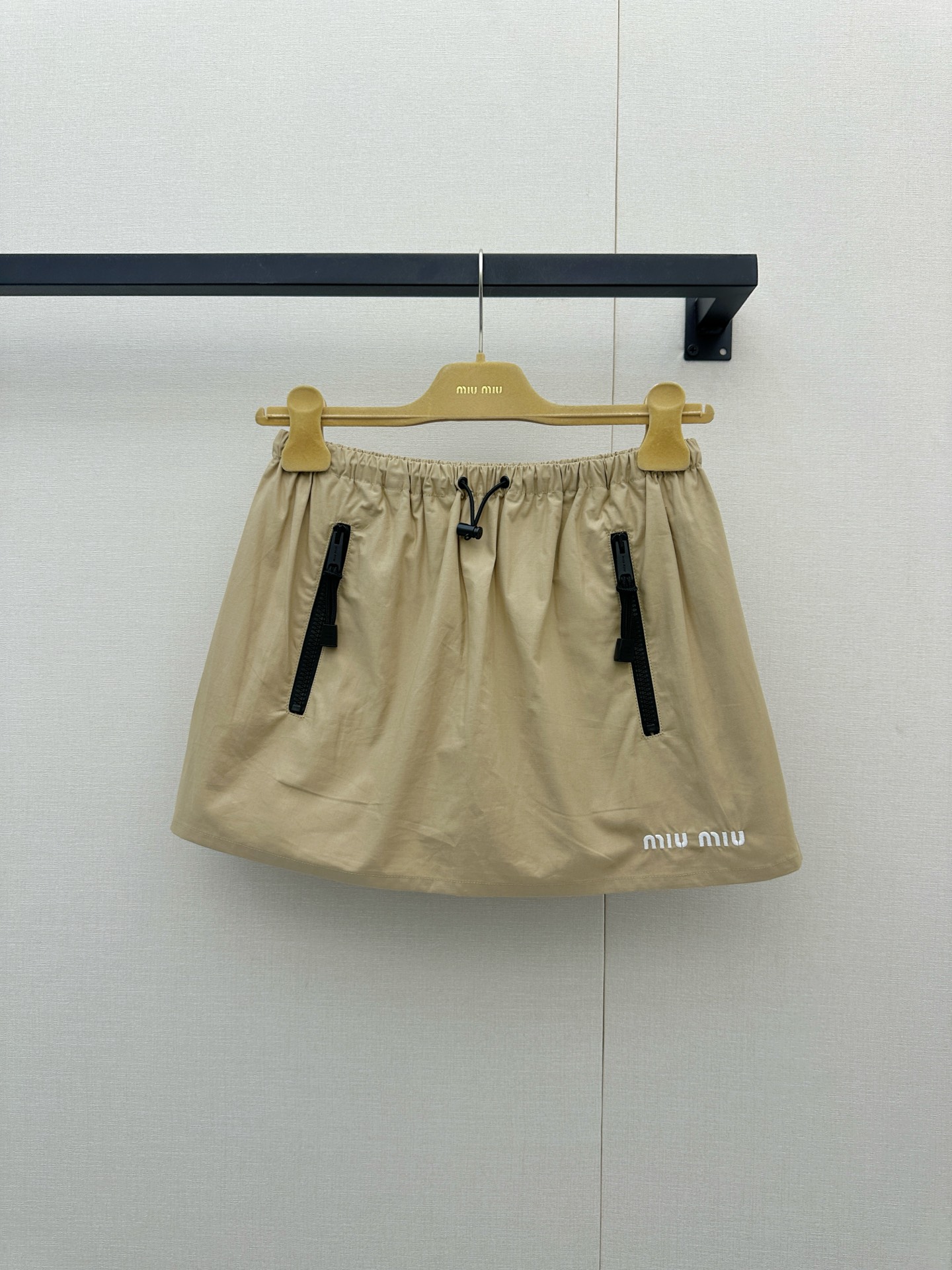 NO:955457,Miu Miu 26's new khaki casual sports suit is simply the natural outfit for sweet and cool girls, it will make people fall in love with it at just one glance!  The warm khaki tone comes with a high-end retro filter, and the top is designed with a neat stand-up collar zipper jacket, paired with a delicate white 'MIU  MIU' chest embroidery and black zipper details, the elastic drawstrings on the hem and cuffs perfectly outline a casual silhouette; the same-color skirt on the lower body is even more playful, the elastic waistband is super easy to put on and take off, the cool zipper pockets on both sides echo the brand embroidery on the skirt, and the light fabric makes every turn flexible  Elegant. The whole outfit cleverly combines functional style with girlishness. It can easily create an effortlessly fashionable atmosphere without having to worry about matching. Whether it is a daily outing or a weekend vacation, it can make you full of energy and turn heads. It is really an indispensable treasure set in the wardrobe, which can easily make you look beautiful all season long!  Actual shots of large products,,miumiu,skirts,jackets & coats,19860909Miu Miu 26新款卡其色休闲运动套装简直是甜酷女孩的本命穿搭,让人一眼就狠狠心动呀！ 温暖的卡其色调自带高级复古滤镜,上衣采用利落的立领拉链夹克设计,搭配精致的白色“MIU MIU”胸前刺绣与黑色拉链细节,下摆和袖口的抽绳松紧完美勾勒出随性轮廓；下半身的同色系半裙更是俏皮满分,松紧腰头穿脱超方便,双侧酷感拉链口袋与裙摆处的品牌刺绣遥相呼应,轻盈的面料让每一次转身都灵动飘逸.整套穿搭将机能风与少女感巧妙融合,不用费心搭配就能轻松营造出毫不费力的时髦氛围,无论是日常出街还是周末度假,都能让你元气满满、回头率爆表,真的是衣橱里不可或缺的宝藏套装,带你轻松美翻整个季节！大货实拍,,miumiu,skirts,jackets & coats,,Women's clothing