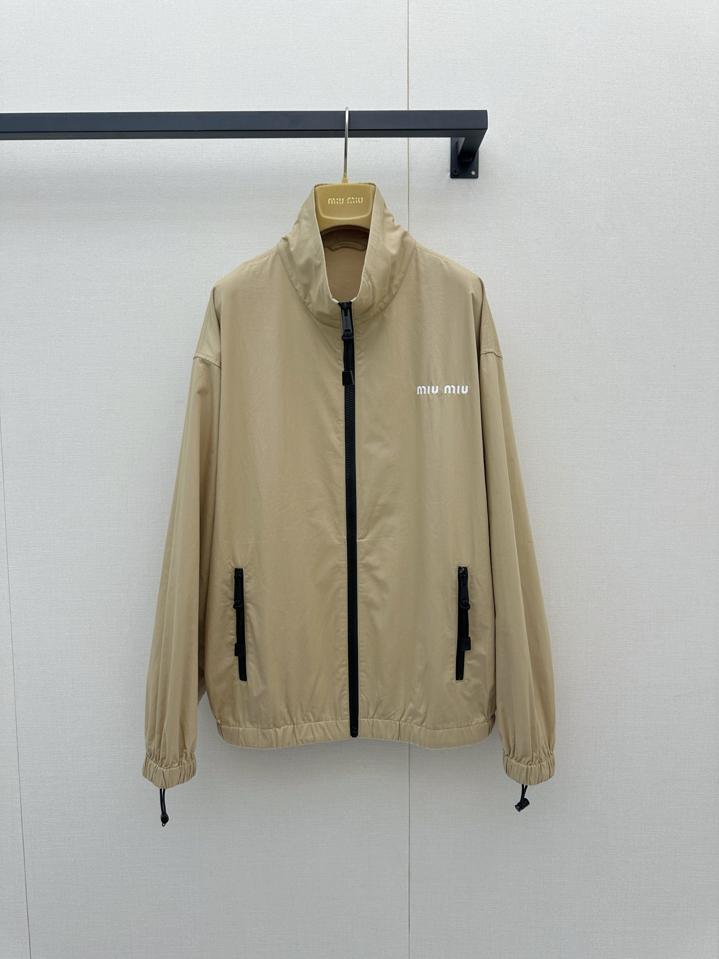NO:955428,Miu Miu 26's new khaki casual sports suit is simply the natural outfit for sweet and cool girls, it will make people fall in love with it at just one glance!  The warm khaki tone comes with a high-end retro filter, and the top is designed with a neat stand-up collar zipper jacket, paired with a delicate white 'MIU  MIU' chest embroidery and black zipper details, the elastic drawstrings on the hem and cuffs perfectly outline a casual silhouette; the same-color skirt on the lower body is even more playful, the elastic waistband is super easy to put on and take off, the cool zipper pockets on both sides echo the brand embroidery on the skirt, and the light fabric makes every turn flexible  Elegant. The whole outfit cleverly combines functional style with girlishness. It can easily create an effortlessly fashionable atmosphere without having to worry about matching. Whether it is a daily outing or a weekend vacation, it can make you full of energy and turn heads. It is really an indispensable treasure set in the wardrobe, which can easily make you look beautiful all season long!  Actual photos of large items in sizes SML,,miumiu,skirts,jackets & coats,19860909Miu Miu 26新款卡其色休闲运动套装简直是甜酷女孩的本命穿搭,让人一眼就狠狠心动呀！ 温暖的卡其色调自带高级复古滤镜,上衣采用利落的立领拉链夹克设计,搭配精致的白色“MIU MIU”胸前刺绣与黑色拉链细节,下摆和袖口的抽绳松紧完美勾勒出随性轮廓；下半身的同色系半裙更是俏皮满分,松紧腰头穿脱超方便,双侧酷感拉链口袋与裙摆处的品牌刺绣遥相呼应,轻盈的面料让每一次转身都灵动飘逸.整套穿搭将机能风与少女感巧妙融合,不用费心搭配就能轻松营造出毫不费力的时髦氛围,无论是日常出街还是周末度假,都能让你元气满满、回头率爆表,真的是衣橱里不可或缺的宝藏套装,带你轻松美翻整个季节！尺码SML大货实拍,,miumiu,skirts,jackets & coats,,Women's clothing