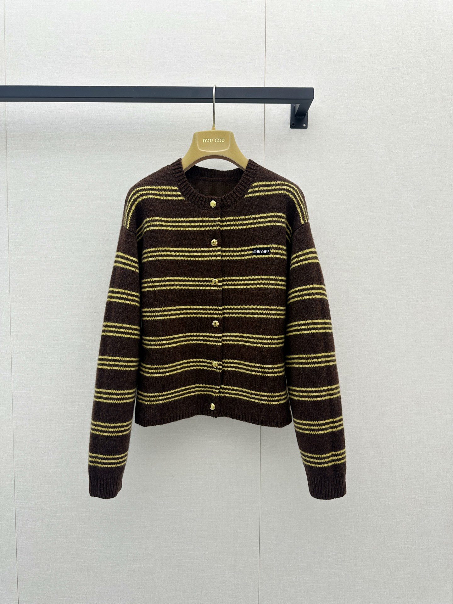 NO:956430,The high version of Miu Miu 26 early autumn new retro brown and yellow striped knitted cardigan is here!  This high-version artifact is definitely the atmospheric ceiling of your autumn and winter wardrobe. It is made of top-grade blended fabrics of 58% sheep wool, 40% cashmere and 2% nylon. It feels soft and delicate, warm and light!  The classic retro dark brown and bright yellow stripes are intertwined, which is visually very eye-catching and has a lazy college atmosphere. The round neck design is matched with exquisite metal buttons, and the chest is embellished with low-key brand embroidery logos. The short and loose version cleverly enhances the waistline, hiding the flesh and showing height. Whether it is layered with a shirt to create a sense of layering, or worn alone with high-waisted jeans to show French laziness, you can easily capture the retro atmosphere of a wealthy woman, and the texture is overwhelming. Sisters, it is definitely not a loss if you close your eyes!  Actual photos of large-scale SML products,,miumiu,jeans,shirts,19860909高版本Miu Miu 26早秋新款复古棕黄条纹针织开衫来啦！这款高版本神器绝对是秋冬衣橱里的氛围感天花板～它采用了58绵羊毛、40山羊绒与2锦纶的顶级混纺面料,触感软糯细腻,保暖又轻盈！经典的复古深棕色与明黄色条纹交织,视觉上超吸睛且自带慵懒的学院气息,圆领设计搭配精致的金属质感纽扣,胸前点缀着低调的品牌刺绣小标,短款宽松版型巧妙提升腰线,藏肉又显高.无论是内搭衬衫叠穿出层次感,还是单穿搭配高腰牛仔裤展现法式慵懒,都能轻松拿捏千金复古氛围,质感爆棚,姐妹们闭眼入绝对不亏哦！尺码SML大货实拍,,miumiu,jeans,shirts,,Women's clothing