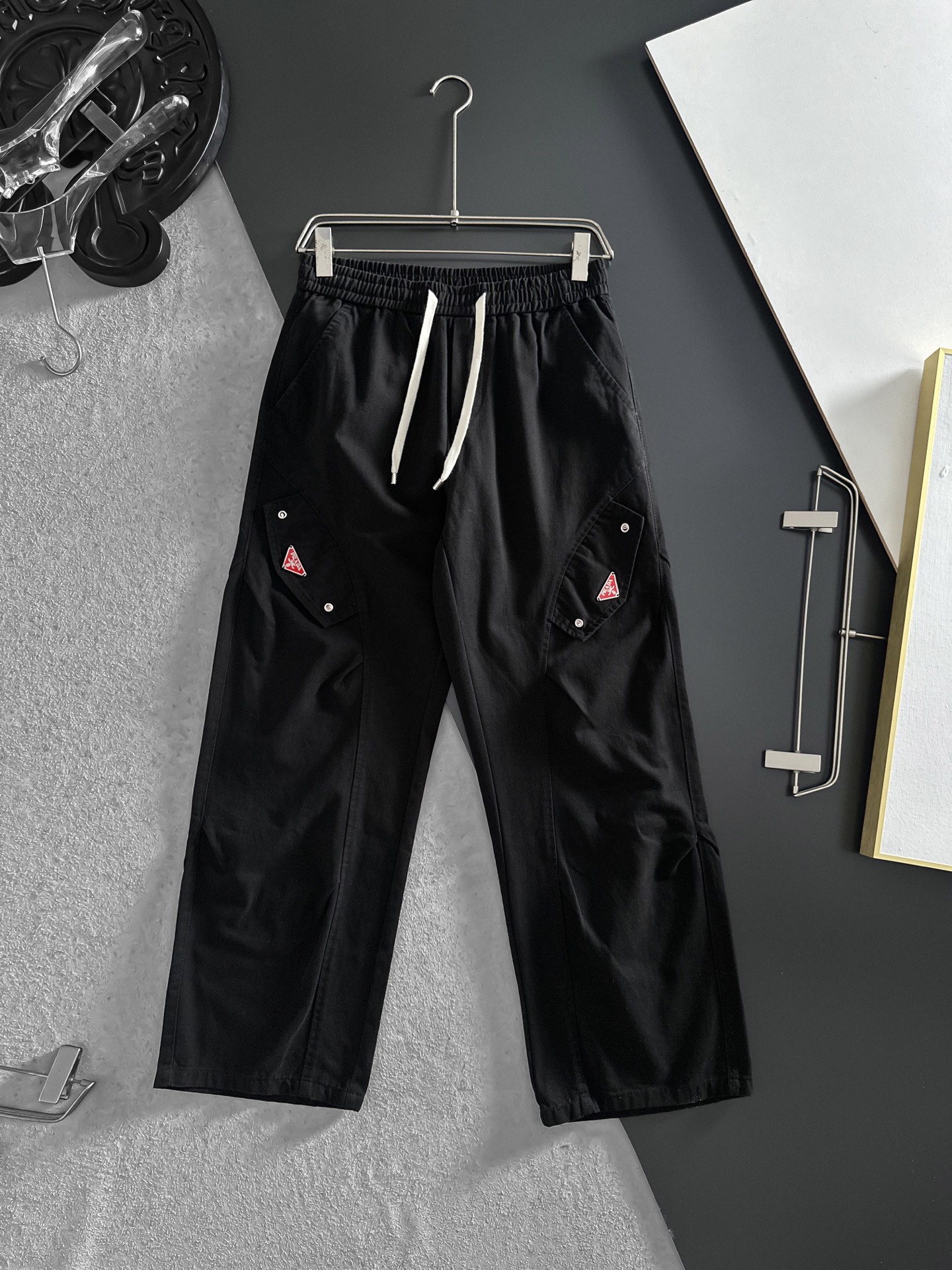 NO:870697,PRADA Black workwear wide-leg pants | The perfect fusion of casualness and practicality. The gentle and calm small tones can easily create a casual atmosphere. The drawstring design at the waist is easy to adjust and can be worn freely. The design of fake pocket caps on both sides makes the overalls have obvious attributes, and the metal buckle details on the pockets add a bit of toughness. The leg-tie style is neat and makes the legs longer. Size M-2XL (shipped next day),, prada, prada, hats,19860909PRADA普拉达 黑色工装阔腿裤 | 随性与实用的完美融合 温柔又沉稳的小色调,轻松就能营造出随性氛围.腰部的抽绳设计,方便调节,穿着无拘无束 . 两侧假口袋帽设计,工装裤属性显著,而且口袋上的金属扣细节,增添了几分硬朗感.束脚的款式利落又显腿长.码数M-2XL（隔天出货）,,prada,prada,hats,,Men's clothing