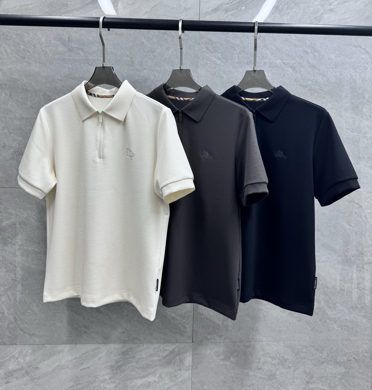 NO:520852,Export foreign trade tail goods!  BUR ace channel!  The new 25-year autumn semi-zipper wool modal blend creates high-end fashion aesthetic design combined with three-dimensional cut men's business fashion casual short-sleeved lapel polo polo shirt. The high-end fashion aesthetic design combined with three-dimensional cut style makes it more comfortable and ornamental. The fabric is selected with excellent lighting, and the high-end modal cotton + wool as raw materials. It is made of a century-old workshop. It is extremely luxurious and special material. The fabric attributes are all excellent. The fabric structure is delicate and natural. After washing, the texture becomes more affinity. Comfort and breathability are perfect. The touch experience is self-evident. It is luxurious and enjoyable!  The details are exquisite and exquisite, showing the quality everywhere. The semi-zippered design shows the sense of high-end. The design conforms to the aesthetic design of Babaoli, uses classic brand elements, and has a classic war horse embroidery brand logo on the chest. The elements are presented, which is very exquisite and pleasing and fashionable, and strongly boasts about the brand identity!  The embroidery elements of the war horse logo on the chest have a strong visual sense, which enhances the sense of fashion, makes the look more advanced and fashionable, and shows a very distinct fashion proposition!  The color matching is light and versatile, suitable for everyday outfits, and the space for mixing and matching is extremely high. You can use any occasion to be fashionable and business casual. The upper body is elegant and has a strong sense of temperament. The wardrobe is fashionable and business casual, and the attendance rate is excellent!  Color off-white Black Dark gray Size (standard version) M-3XL M Shoulder width 42cm Bust 98cm Length 67 L Shoulder width 43.5cm Bust 102cm Length 68 XL Shoulder width 45cm Bust 106cm Length 69 XXL Shoulder width 46.5cm Bust 110cm Length 70 3XL Shoulder width 48cm Bust 114cm Length 71,,burberry,burberry,T-shirt,alexander wang19860909出口外贸尾货！BUR王牌渠道！战马刺绣logo25年秋季新品半拉链羊毛莫代尔混纺打造高端时尚美学设计结合立体裁剪男士商务时尚休闲短袖翻领马球polo衫 高端的时尚美学设计结合立体裁剪的版型,使穿着更具舒适性和观赏性.面料甄选光照极好的上等莫代尔棉+羊毛为原料,经过百年工坊定织定染而成,极为奢华特殊的材质,面料属性皆为上乘,面料结构细腻自然,经过水洗后,肌理变得更具亲和力,舒适性与透气性完美兼备,触感体验不言而喻,奢华极致享受！细节精湛考究,处处尽显品质感. 半拉链设计,尽显高级感.设计符合巴宝*莉美学设计,运用了经典的品牌元素,胸前有经典战马刺绣品牌标识,元素呈现,非常精致讨巧且时髦,有力标榜了品牌身份！胸前战马logo刺绣元素,视觉感极强,提升了时尚感,让造型变得更具高级和时髦,展现出极具鲜明时尚主张！配色轻熟百搭,符合日常各种穿搭,混搭兼容空间极高,驾驭任何场合,时尚商务休闲皆可,上身儒雅气质感极强,衣橱时尚商务休闲绝佳的高出勤率！ 颜色米白色 黑色 深灰色 尺码（标准版型）M-3XL码 M码 肩宽42cm 胸围98cm 衣长67 L码 肩宽43.5cm 胸围102cm 衣长68 XL码肩宽45cm 胸围106cm 衣长69 XXL码肩宽46.5cm 胸围110cm 衣长70 3XL码肩宽48cm 胸围114cm 衣长71,,burberry,burberry,T-shirt,alexander wang,Men's clothing