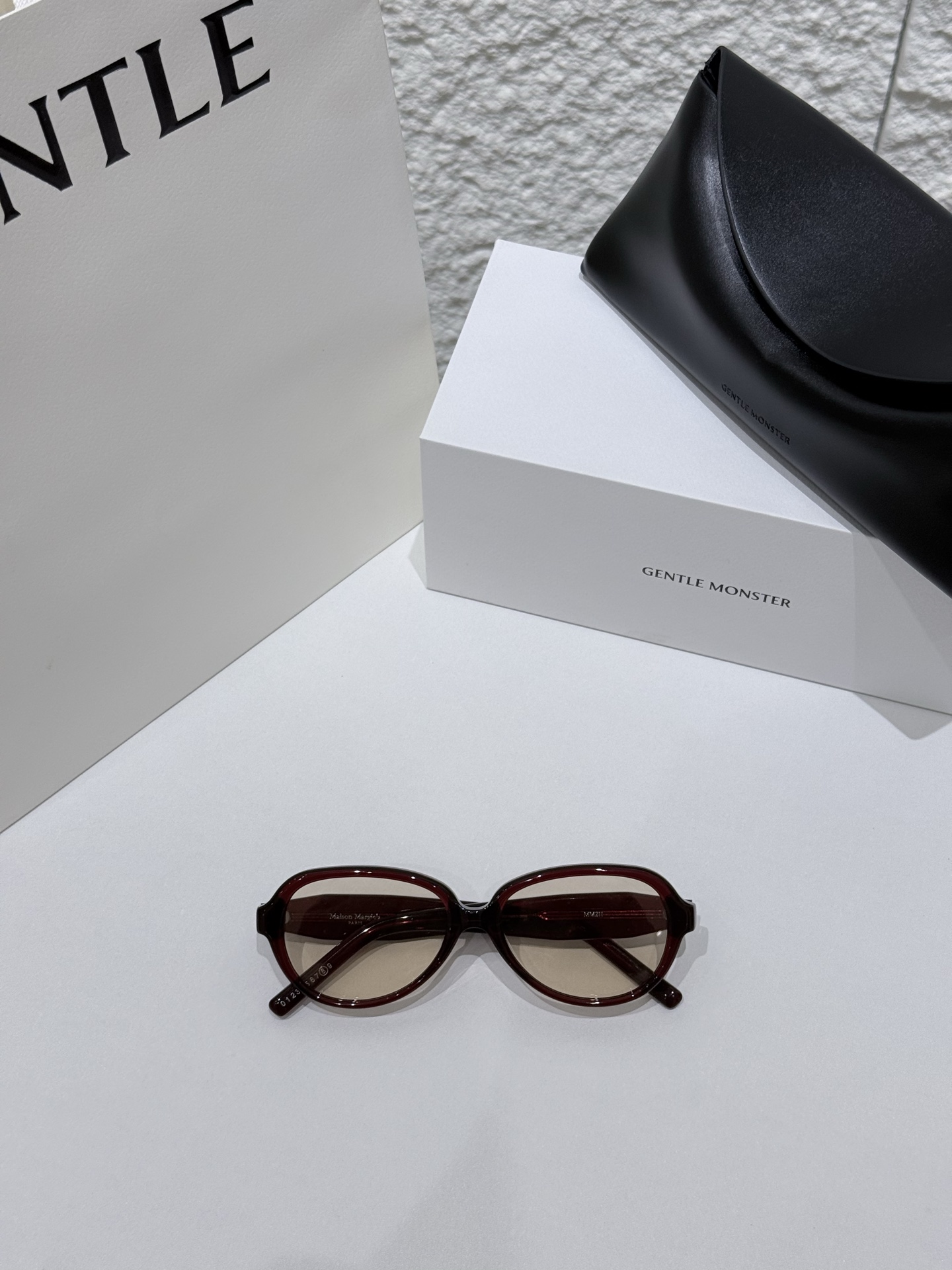 GENTLEMONSTER×MAISONMARGIELA联名款MM211太阳镜以先锋型材与极简美学，诠释两大品牌的前沿设计语言，打造兼具质感与辨识度的高端光学单品。镜框甄选高纯度醋酸纤维板材一体注塑成型，经多道精密抛光与打磨，质地坚韧耐用、光泽细腻温润，同时保持轻盈佩戴感，长时间无压感。板材纹理均匀、抗变形、耐老化，适配多元场景。镜腿处饰有标志性四角缝线标识，细节处彰显联名专属格调，轮廓利落、线条流畅，平衡硬朗与柔和。\n镜片采用高清尼龙光学材质，提供UV400全波段防护，高效阻隔紫外线与强光，视野清晰柔和、无畸变。色调设计兼顾视觉舒适与时尚层次，适配日常出行、户外休闲等场景。遵循人体工学弧度，镜腿贴合耳际、鞍形鼻托舒适不压鼻，佩戴稳固不易滑落。\n男女同款\n尺寸：56-16-144\n