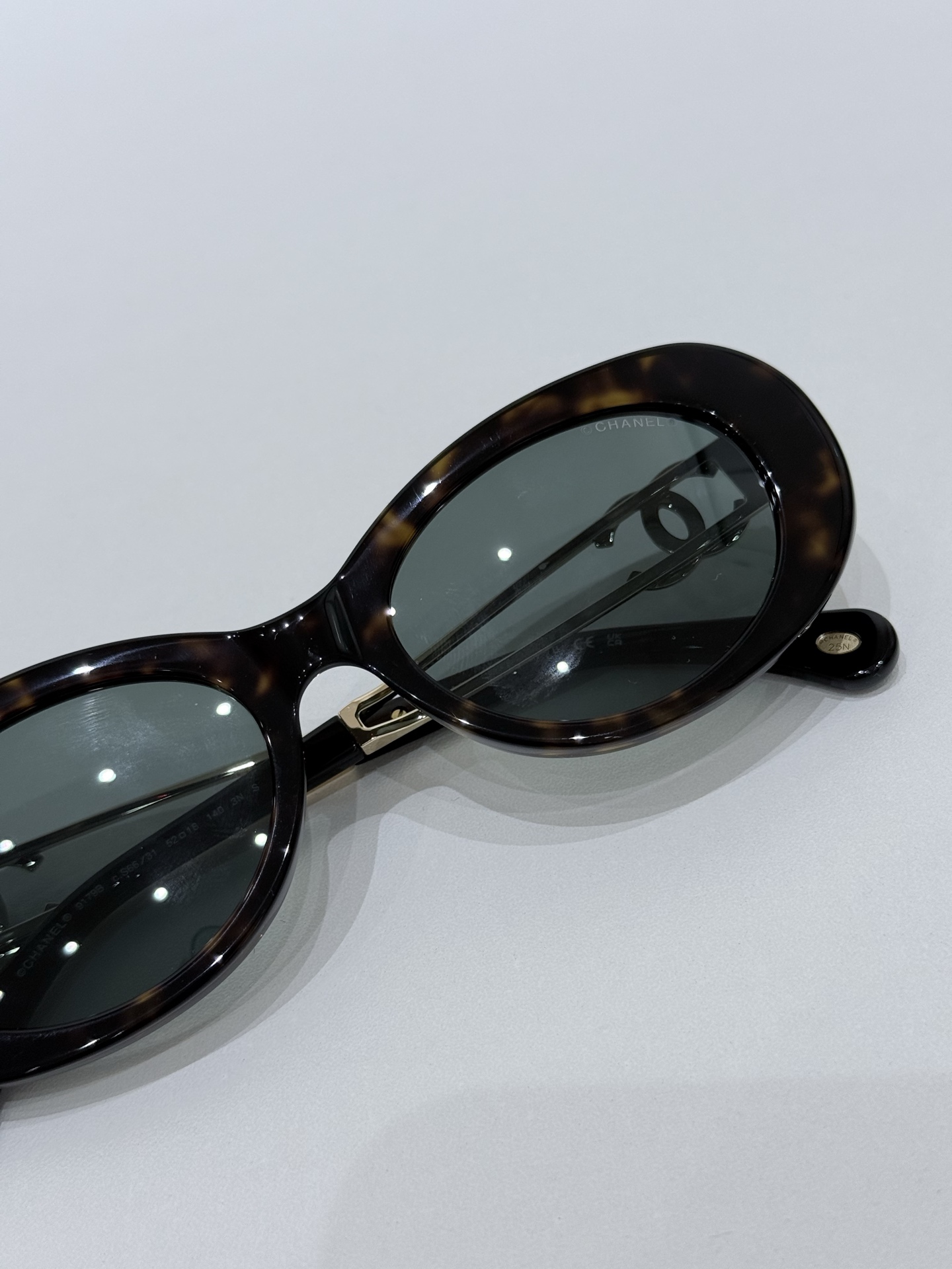 CHANEL\/香奈儿9179B太阳镜镜框甄选高品质醋酸纤维材质，经意大利精湛工艺塑形打磨，质地轻盈坚韧且富有温润光泽，兼具出色的佩戴舒适度与耐用性，精准贴合面部轮廓而无压迫感。镜架巧妙融入金属元素点缀，与醋酸纤维材质形成质感碰撞，细节处彰显匠心。标志性双C标识以精致工艺嵌入镜腿，既是品牌基因的鲜明彰显，亦是奢华品质的无声佐证。镜片采用UV3级防护标准，100%阻隔UVA\/UVB射线，严格遵循CE认证标准，在强效护目的同时保持视物清晰通透，可适配近视镜片定制需求。整体型材设计兼顾美学与实用性，120mm镜框宽度搭配140mm镜腿长度，适配多元脸型，尽显修饰力。\n男女同款\n尺寸：52-18-140