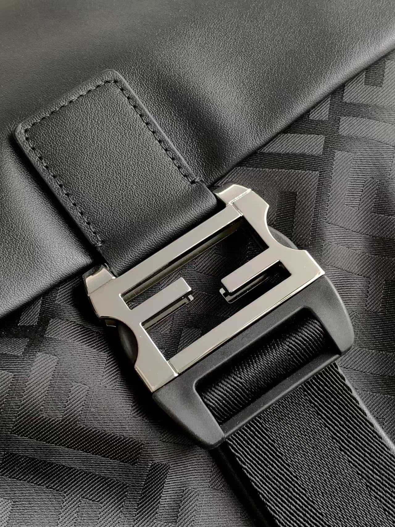 Prada Flux背包采用黑色薄垫FF尼龙材质 具有略带凸纹的高级质感 黑色光面牛皮革翻盖