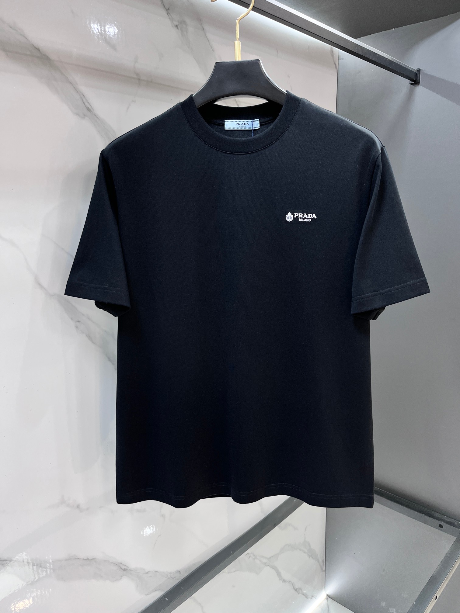 NO:839182,Prada 2026 spring and summer counter new style, simple short sleeves with logo badge, double yarn pure cotton fabric, diversified matching, catering to the current innovative trend of fashion cutting-edge, collision of retro and modern elements, extreme violent aesthetics. Fashion matching, three standards complete!  ……………………………………………………………… SizeM-XXXL,,prada,T-shirt,19860909普拉达 2026春夏专柜新款,logo徽章简约短袖 双纱纯棉面料 多元化搭配 迎合眼下时尚前沿的创新趋势 复古与现代化元素的碰撞 极端的暴力美学.时尚搭配 三标齐全！…………………………………………………… SizeM-XXXL,,prada,T-shirt,,Men's clothing