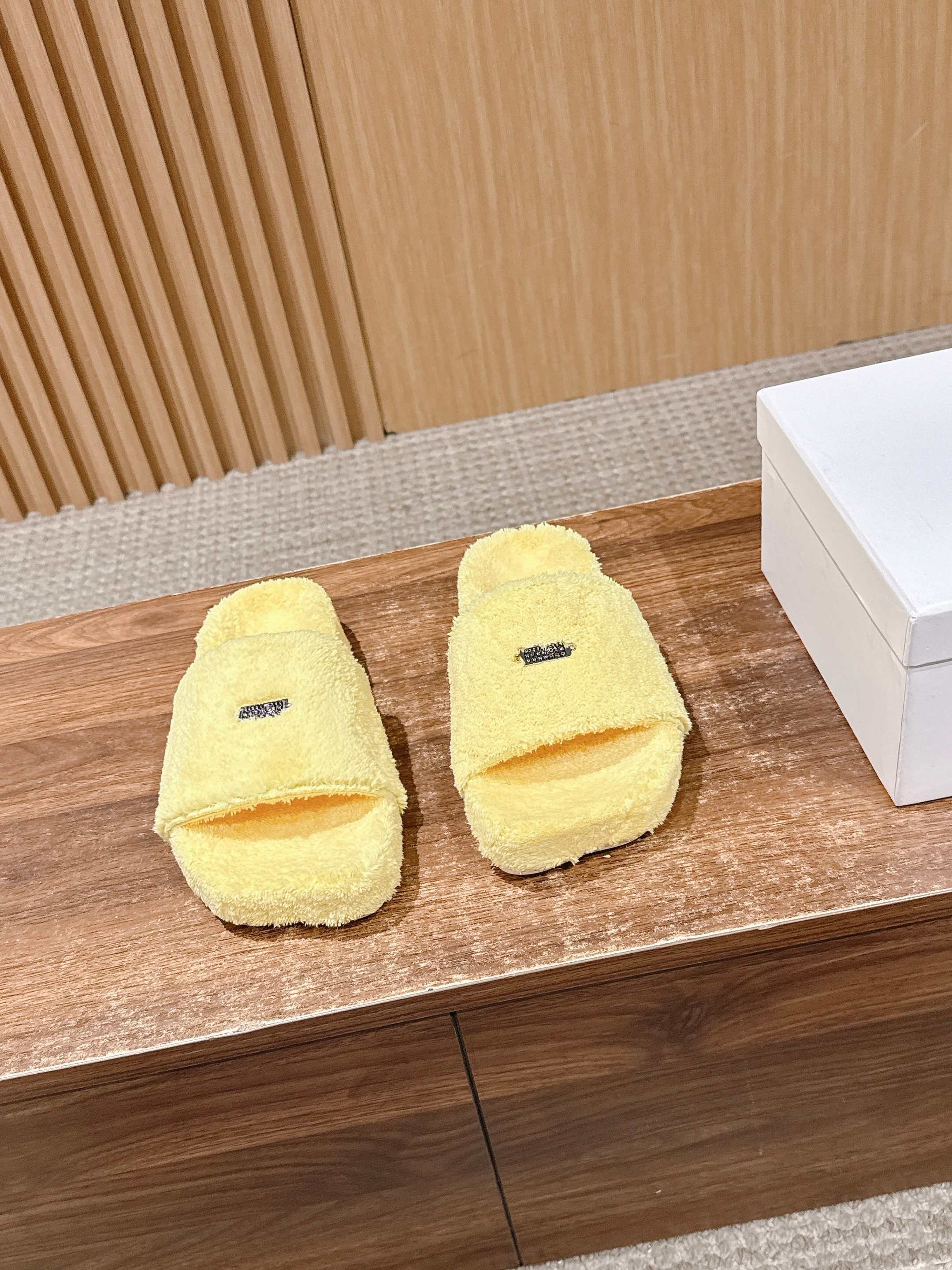 NO:696122,Maison Margiela's new thick-soled flat-top plush slippers have soft and fluffy suede, strong skin-friendliness, and feel like stepping on clouds; the soles are made of rubber, non-slip and wear-resistant, and are practical for home and outings. The inner lining and insole are wrapped in the same material, without the problem of hard edges grinding the feet, and have excellent warmth in winter. The shoe body has Margiela's iconic number label, which is low-key and brand-recognizable; the classic one-strap slipper version is simple and neat.  The colors are rich, covering black, off-white, caramel brown, pink, bright yellow, etc. There are both basic and versatile styles, as well as eye-catching candy colors, suitable for different dressing styles. The version is flat and loose, which does not squeeze the feet and is suitable for a variety of foot types. It can be worn at home, commuting, shopping and other scenes. Cashmere cloth upper, cashmere cloth lining, outsole, rubber outsole, height increased by 3cm, size 35-40 (40 size customization is not returnable), slippers, masion  margiela,slippers19860909Maison Margiela 马吉拉新款厚底平头毛绒拖鞋 绒面柔软蓬松,亲肤性强,脚感如同踩在云朵上；鞋底为橡胶材质,防滑耐磨,兼顾居家与外出的实用性.内里与鞋垫同材质包裹,无硬边磨脚问题,冬季穿着保暖性优异.鞋身带有马吉拉标志性的数字标签,低调又具品牌辨识度；经典一字带拖鞋版型,简约利落. 配色丰富,涵盖黑色、米白、焦糖棕、粉色、明黄等,既有基础百搭款,也有亮眼的糖果色选择,适配不同穿搭风格.版型为平底宽松款,不挤脚且适配多种脚型,居家、通勤、逛街等场景均可穿着. 鞋面羊绒布 内里羊绒布 大底橡胶大底 增高3cm size35-40码（40码定制不退换）,拖鞋,masion margiela,slippers,Women's Shoes