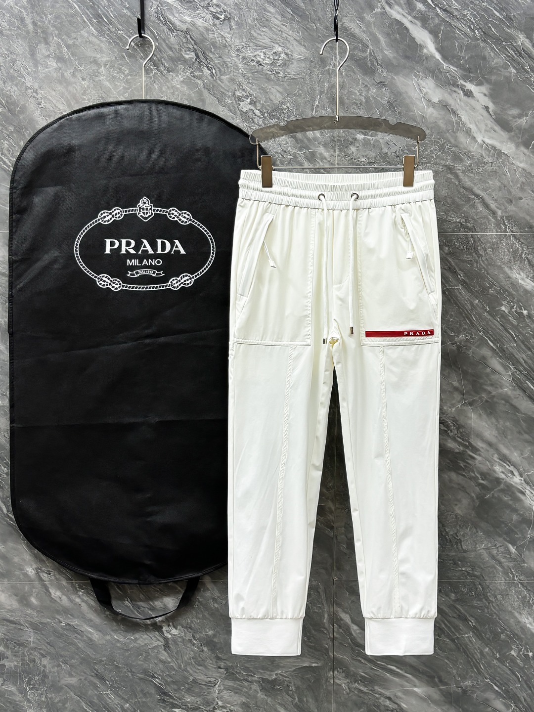 NO:136262,PRADA# 2025 Tiansi Nylon four-sided spring and summer casual pants. A new interpretation of aesthetics, interprets a rich style of style and style, with a strong sense of detail and design. The classic brand logo is used as a color combination to interpret classic brand fashion, adding luster to the overall shape. Imported fabrics are light and refreshing, soft and comfortable. The inner weaving surface is flat and breathable, simple and unique charm. European trade channels, Italian overseas warehouse straight hair, and overseas boutique limited sales. 25 spring and summer new casual and fashionable trousers, these trousers use the design of big brands to create a fashionable and trendy style, with exquisite details and in place, showing super high quality.  The trousers are decorated with iconic brand logos, highlighting the brand style, creating fashionable and diverse styles. The imported fabric is carefully crafted, soft and comfortable, and skin-friendly and breathable. It is a pair of pants that are comfortable for both home and out. You can go out with a T-shirt Polo~ Color black and white Size: M L XL 2XL 3XL M size waist 74- hip 98- pants length 99- foot mouth 24 L size waist 78- hip 102- pants length 99- foot mouth 25 XL size waist 82- hip 106- pants length 100- foot mouth 26 2XL size waist 86- hip 110- pants length 101- foot mouth 27 3XL size waist 90- hip 114- pants length 102- foot mouth 28,,prada,tees,t-shirt,alexander wang19860909PRADA# 2025 天丝锦纶四面弹春夏休闲裤子 美学的焕新诠释,演绎浓郁的格调型时尚风范,细节感和设计感强悍.经典品牌标识做为色彩搭配,演绎经典的品牌时尚,为整体造型增光添彩.进口面料,轻薄清爽,柔软舒适.内里织面平整透气性极佳,简洁而富有独特魅力. 欧洲贸易渠道,意大利海外仓直发,海外精品限定销售.25春夏新款休闲时尚长裤,这款长裤采用大牌的设计打造时尚潮流感,细节处理精致到位,展现超高的品质. 裤身上点缀标志性品牌标识,彰显品牌格调,打造时尚多样的造型.进口面料精心打造,柔软舒适,还亲肤透气,是居家和外出都很舒适的一款裤子,随便搭个T恤Polo就可以出门啦~ 颜色黑色 白色 尺码:M L XL 2XL 3XL M码腰围74-臀围98-裤长99-脚口24 L码腰围78-臀围102-裤长99-脚口25 XL码腰围82-臀围106-裤长100-脚口26 2XL码腰围86-臀围-110-裤长101-脚口27 3XL码腰围90-臀围114-裤长102-脚口28,,prada,tees，t-shirt,alexander wang,Men's clothing