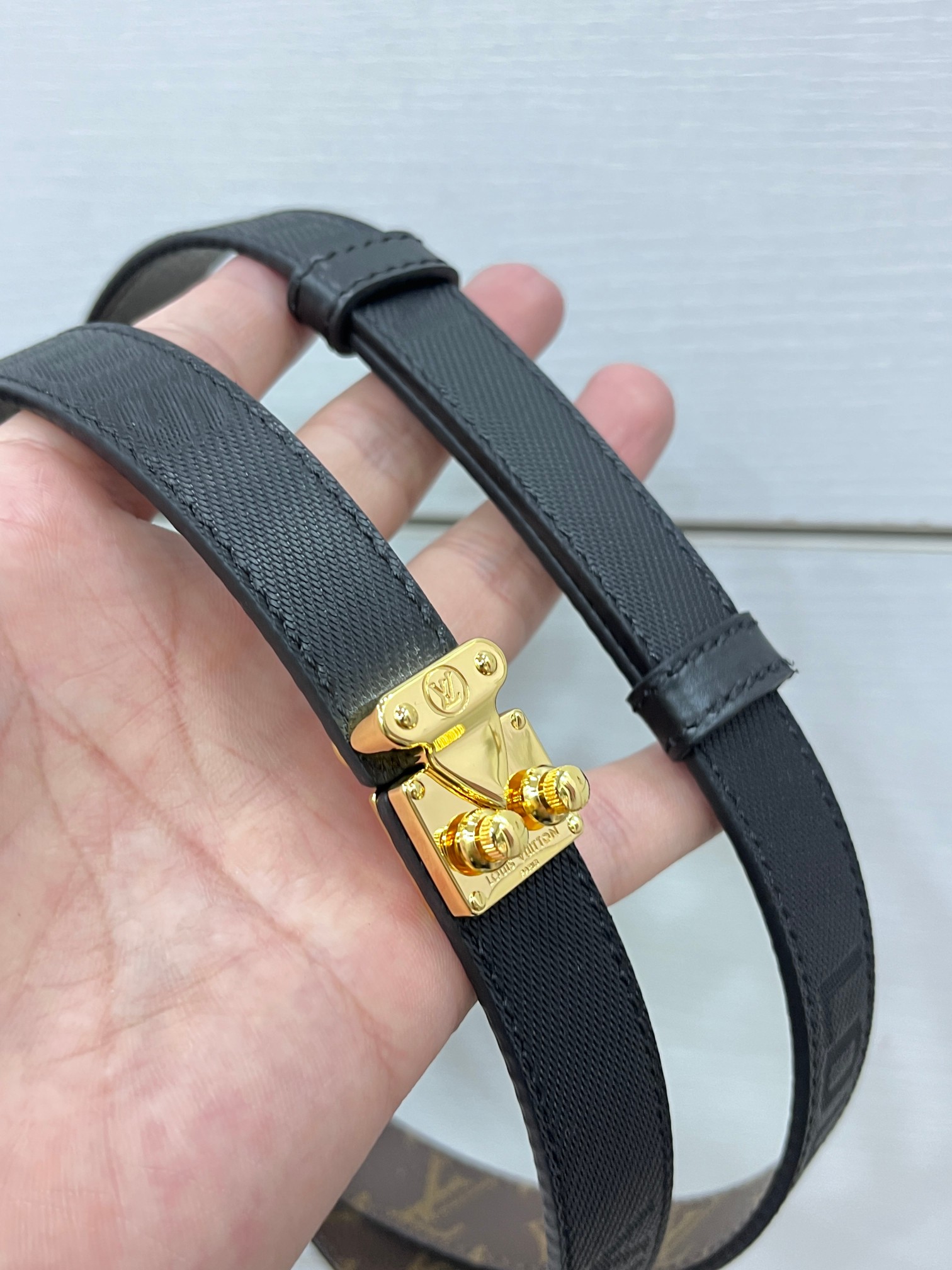 2.0黑色Serrures 腰带取材牛皮革，以耀目 S-Lock 搭扣致意品牌传统硬箱。路易威登标识压纹