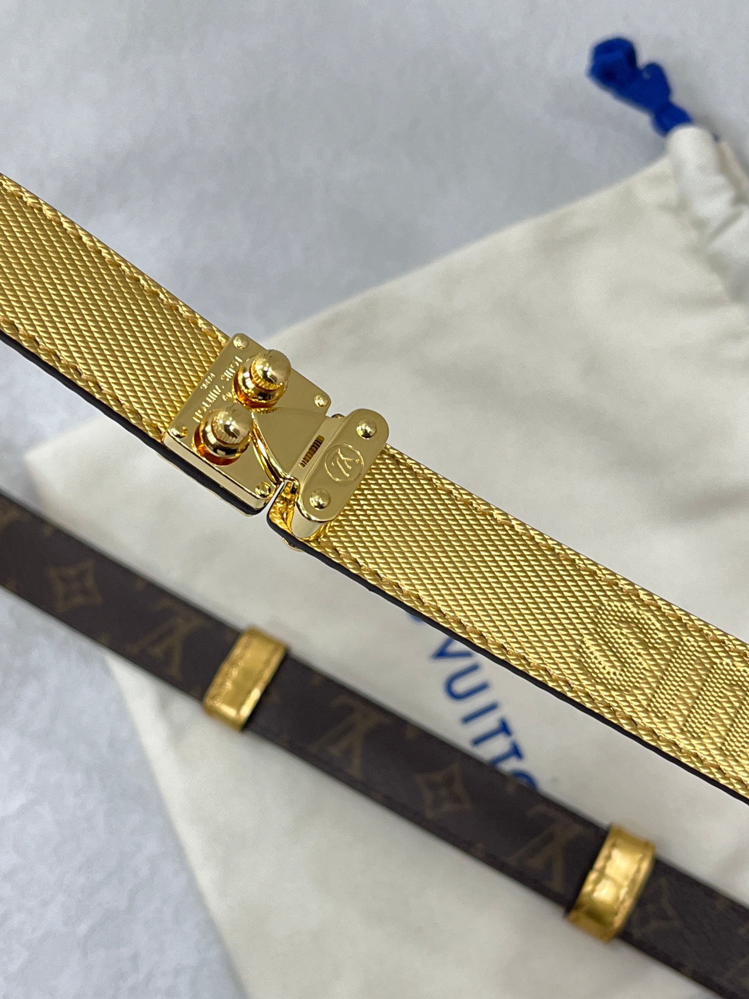 咖色边Serrures 腰带取材牛皮革，以耀目 S-Lock 搭扣致意品牌传统硬箱。路易威登标识压纹和 