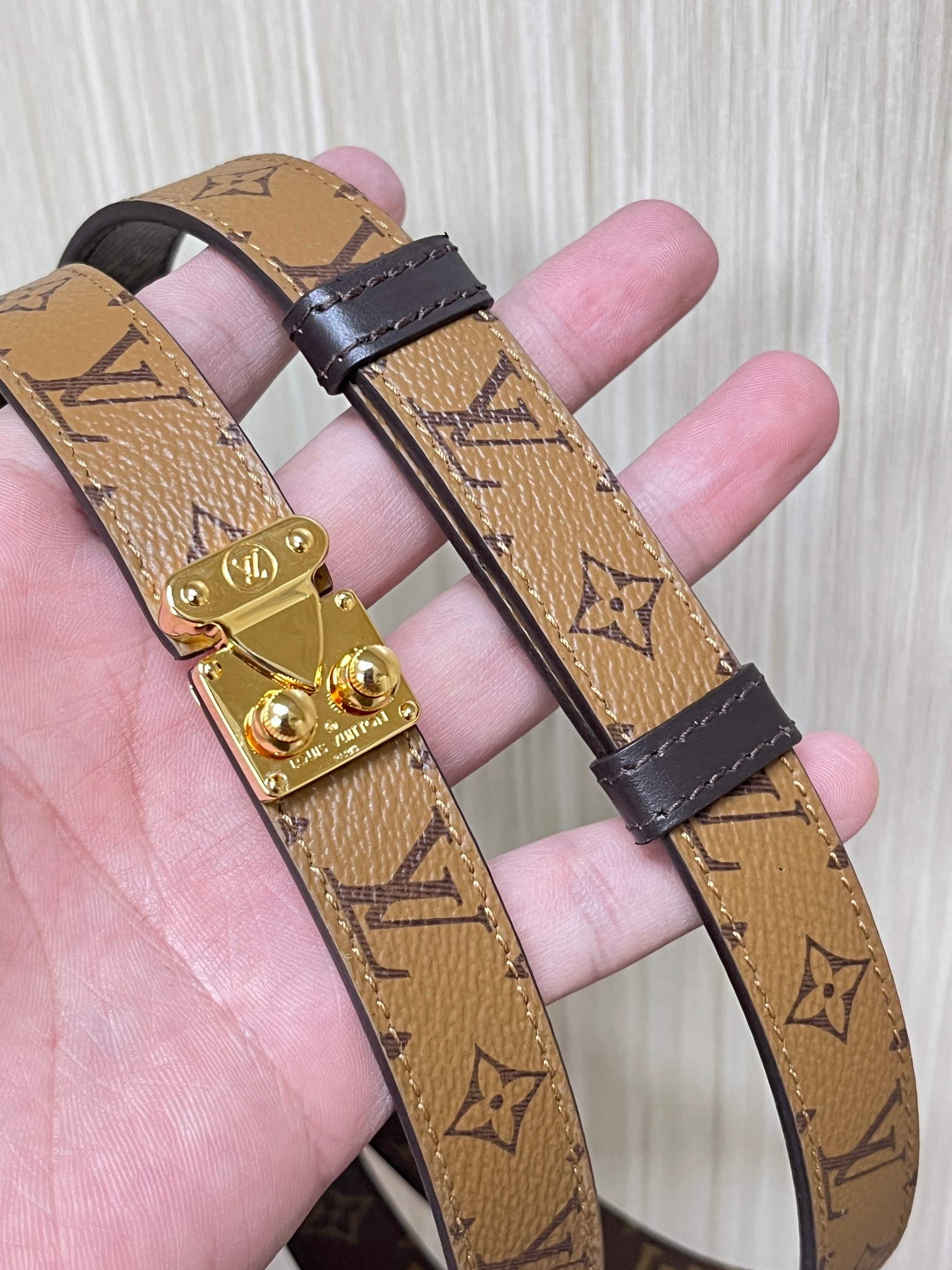 2.0宽双面帆布印花， 腰带取材牛皮革，以耀目 S-Lock 搭扣致意品牌传统硬箱。路易威登标识压纹和 