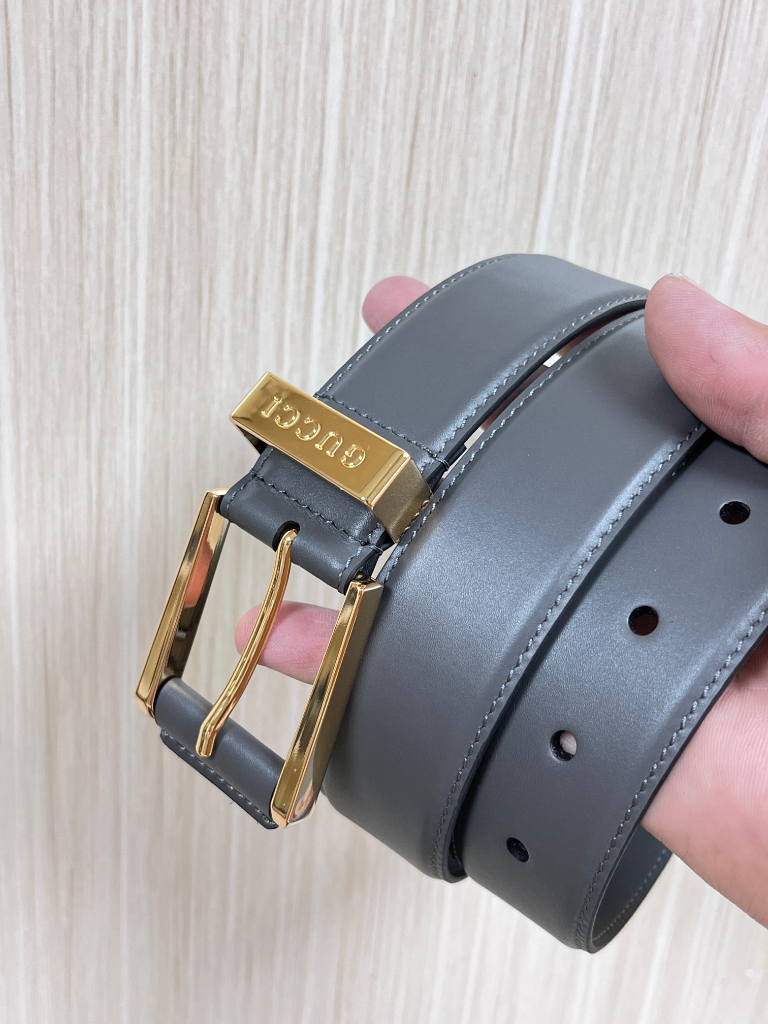 当季新款，中性色调精致牛皮革与方形搭扣完美合璧，不经意间散发商务正装风范。这款宽版腰带精选光面牛皮革制作