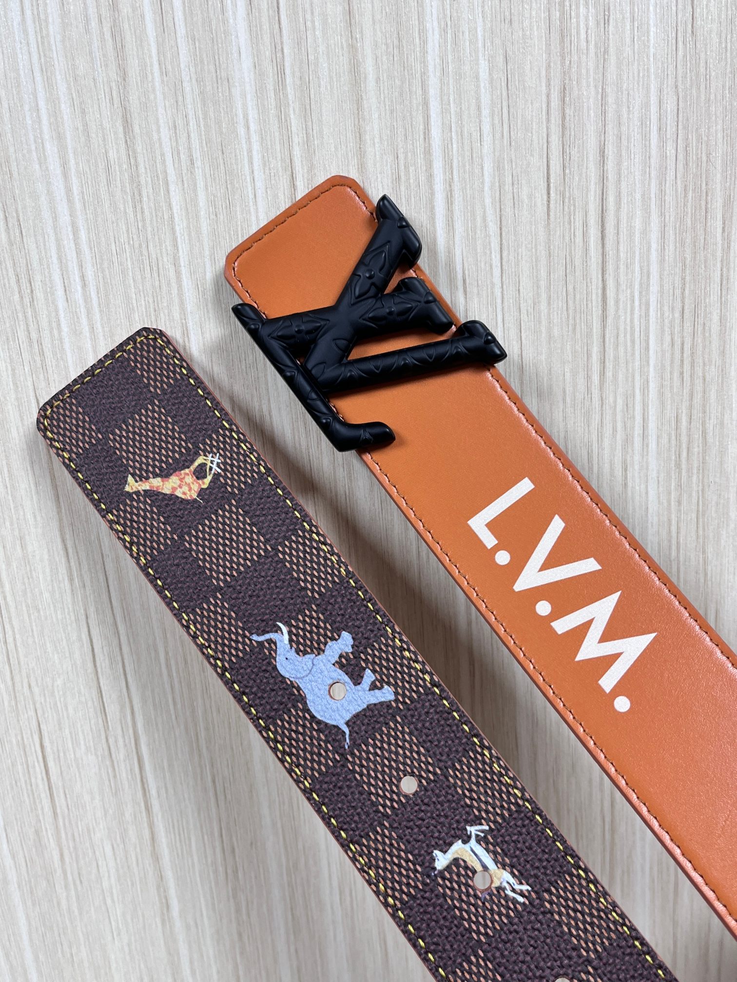 本款 LV Initiales 40 毫米双面腰带以电影叙事为灵感，气质颇具神秘魅力。Damier 格纹