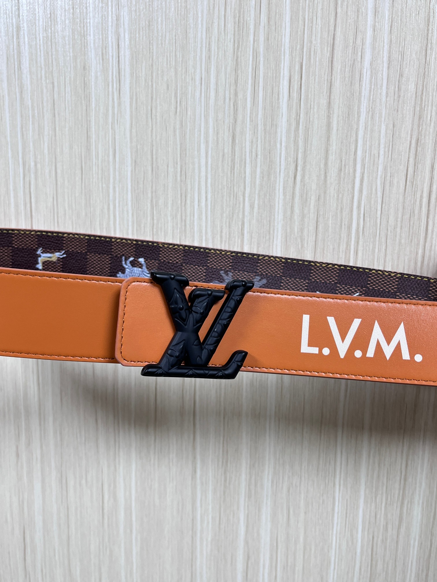 本款 LV Initiales 40 毫米双面腰带以电影叙事为灵感，气质颇具神秘魅力。Damier 格纹