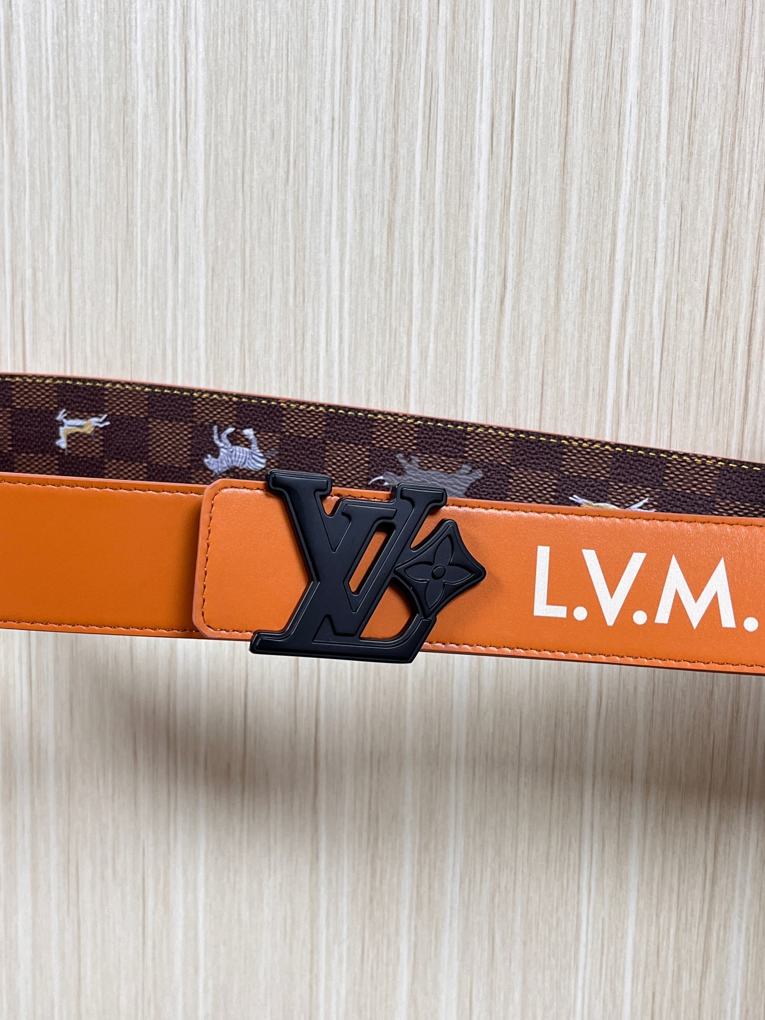 本款 LV Initiales 40 毫米双面腰带以电影叙事为灵感，气质颇具神秘魅力。Damier 格纹