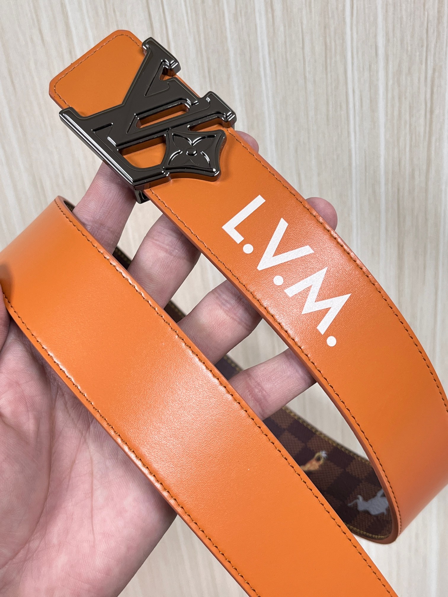 本款 LV Initiales 40 毫米双面腰带以电影叙事为灵感，气质颇具神秘魅力。Damier 格纹