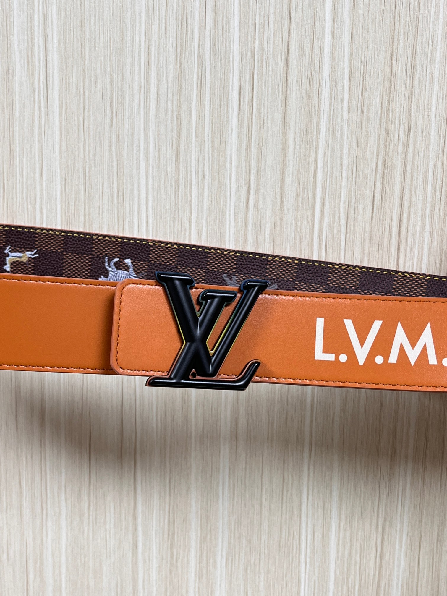 本款 LV Initiales 40 毫米双面腰带以电影叙事为灵感，气质颇具神秘魅力。Damier 格纹