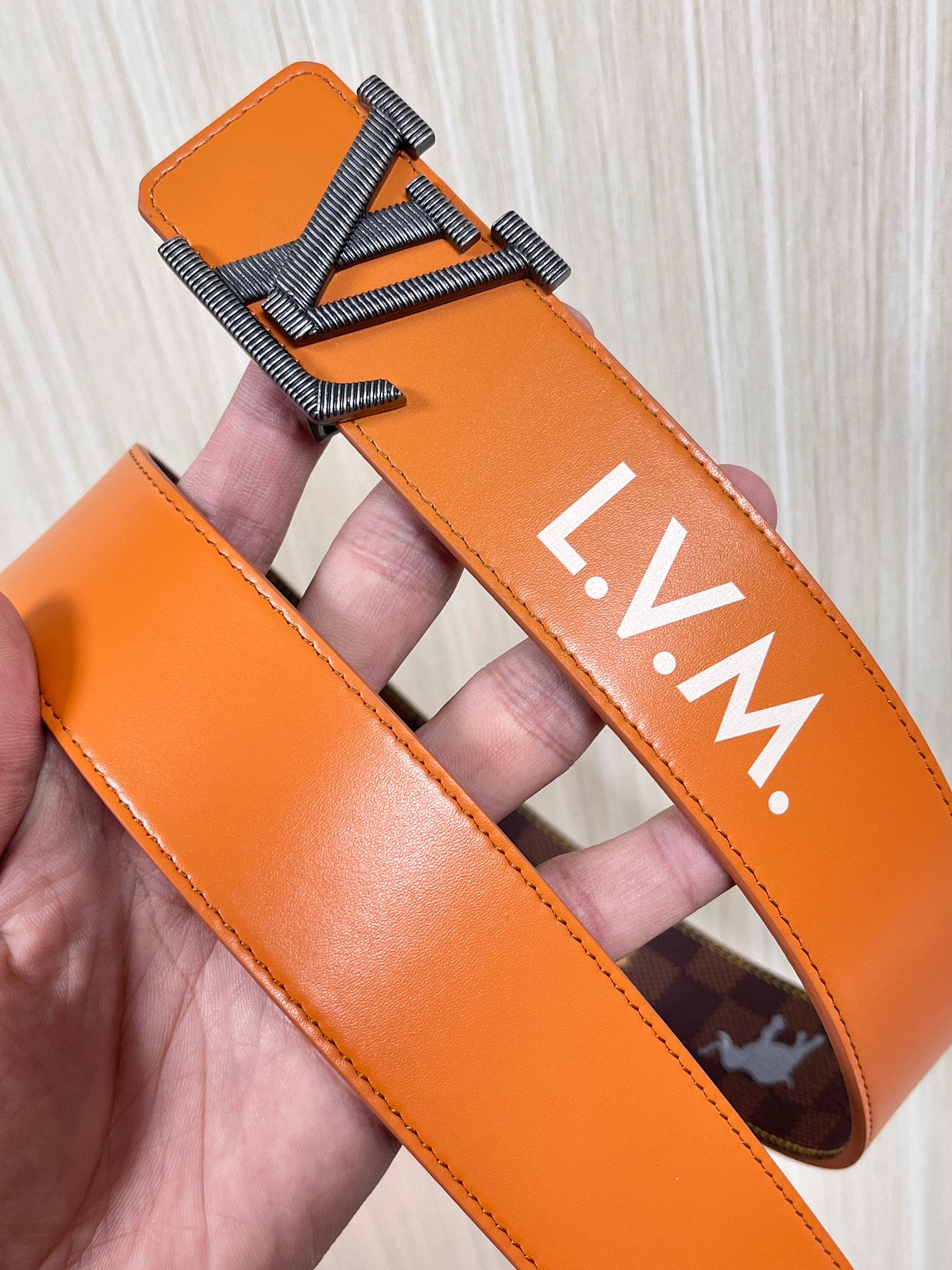 本款 LV Initiales 40 毫米双面腰带以电影叙事为灵感，气质颇具神秘魅力。Damier 格纹