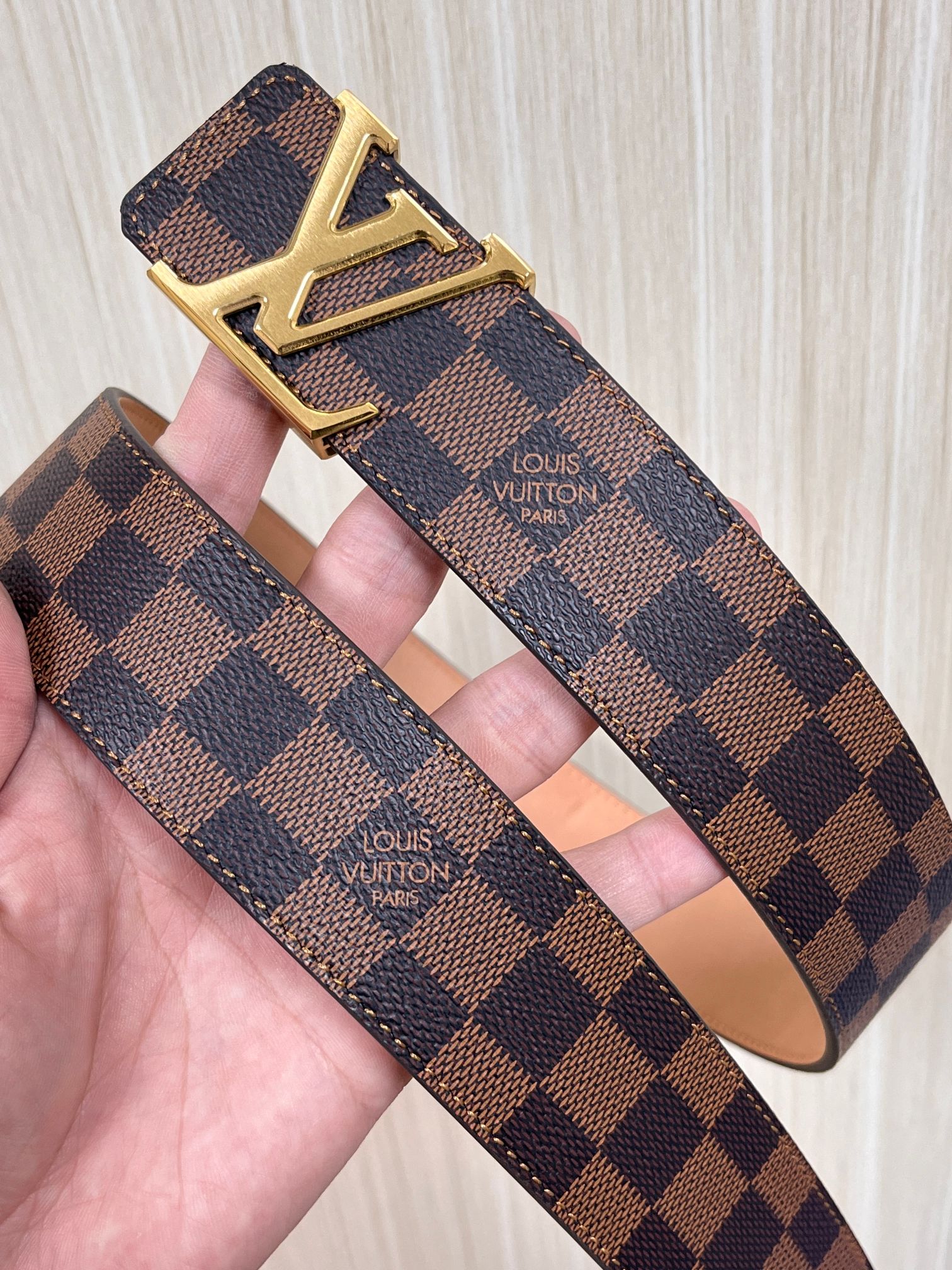 本款 LV Initiales 40 毫米双面腰带以电影叙事为灵感，气质颇具神秘魅力。Damier 格纹