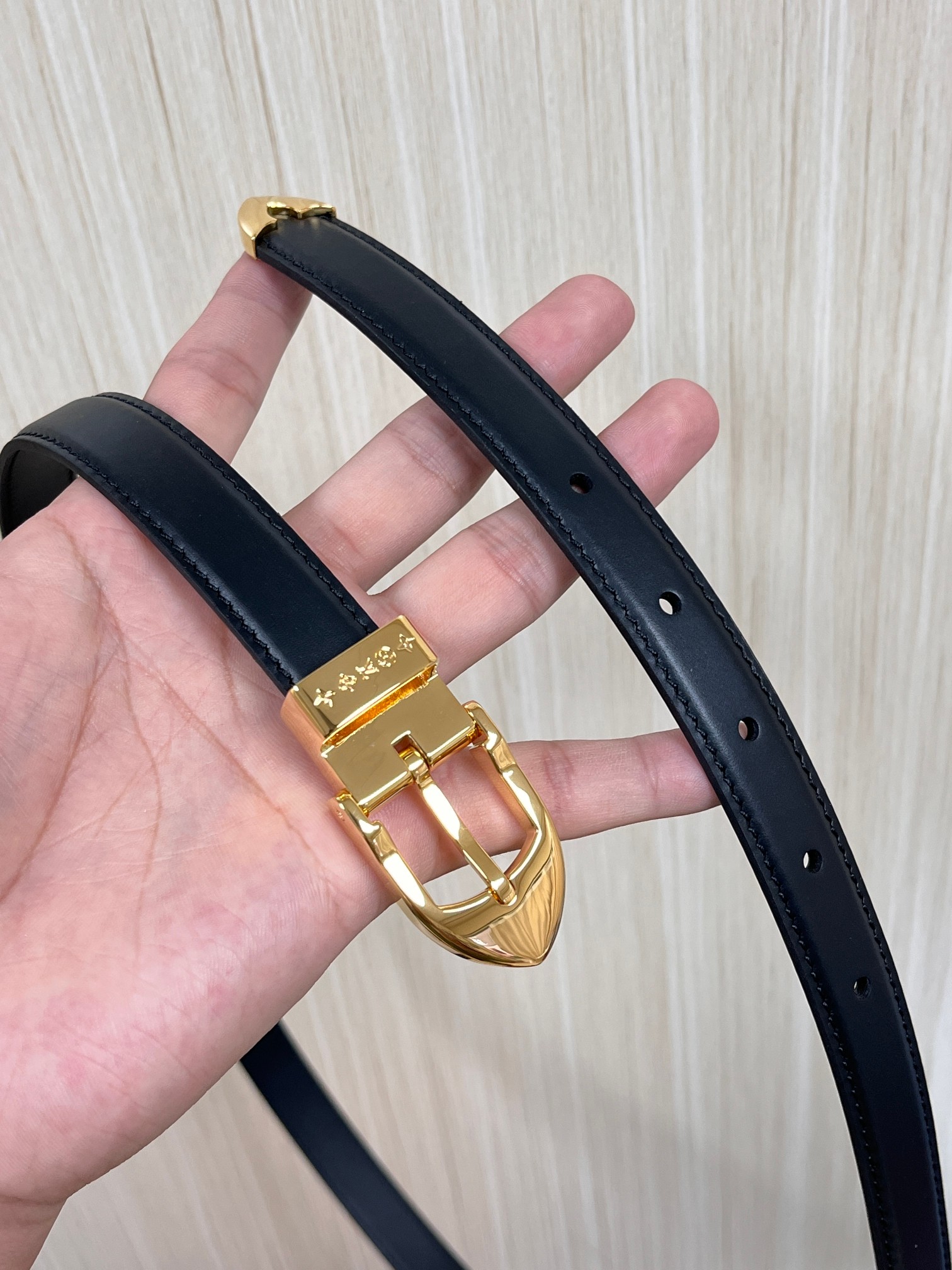 当季新款， 腰带拥有纤细皮革带，为考究针式搭扣镂刻 5 Elements 标识。尖形末端廓形勾勒 Mon