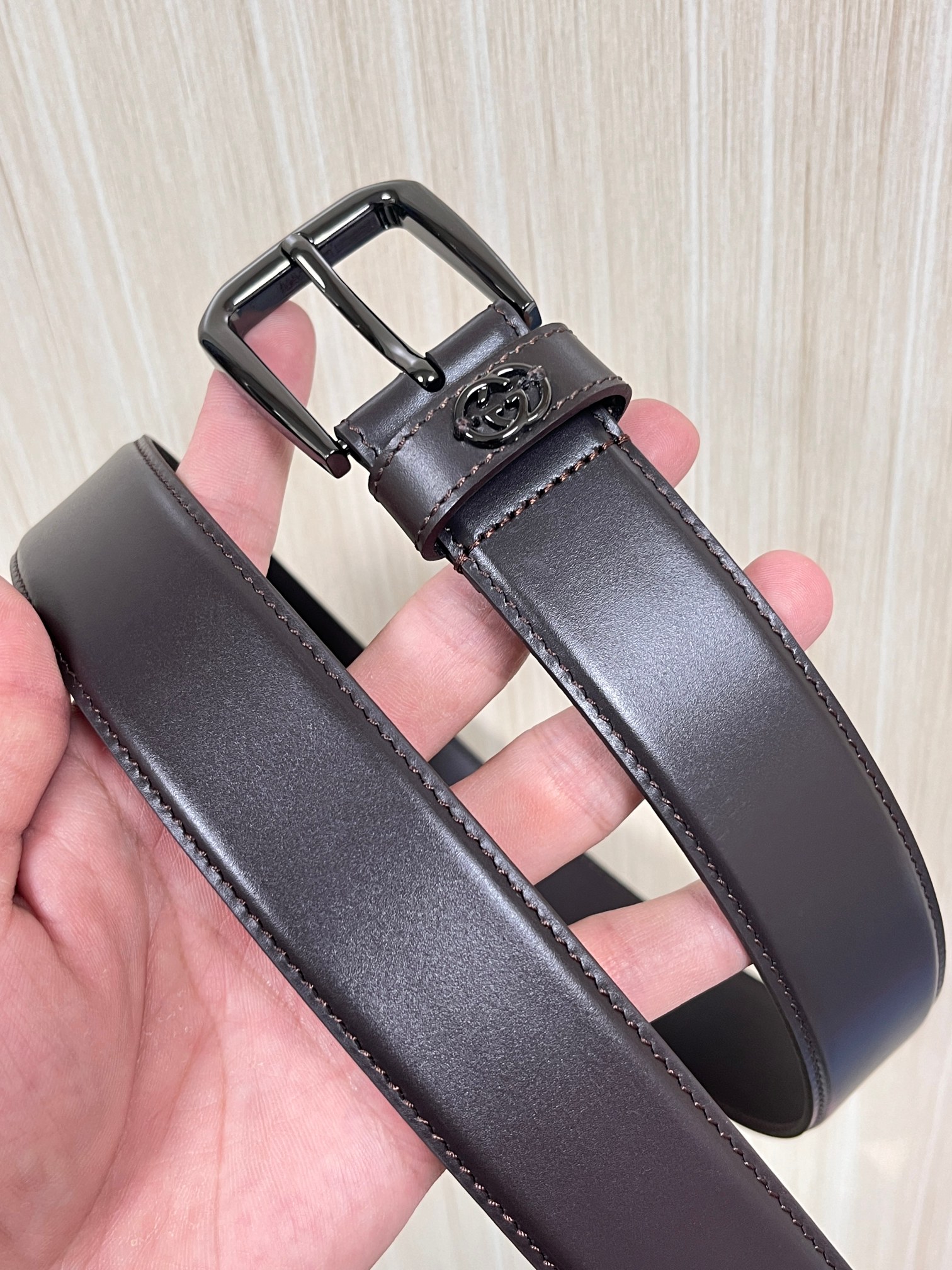 当季新款，中性色调精致牛皮革与方形搭扣完美合璧，不经意间散发商务正装风范。这款宽版腰带精选光面牛皮革制作