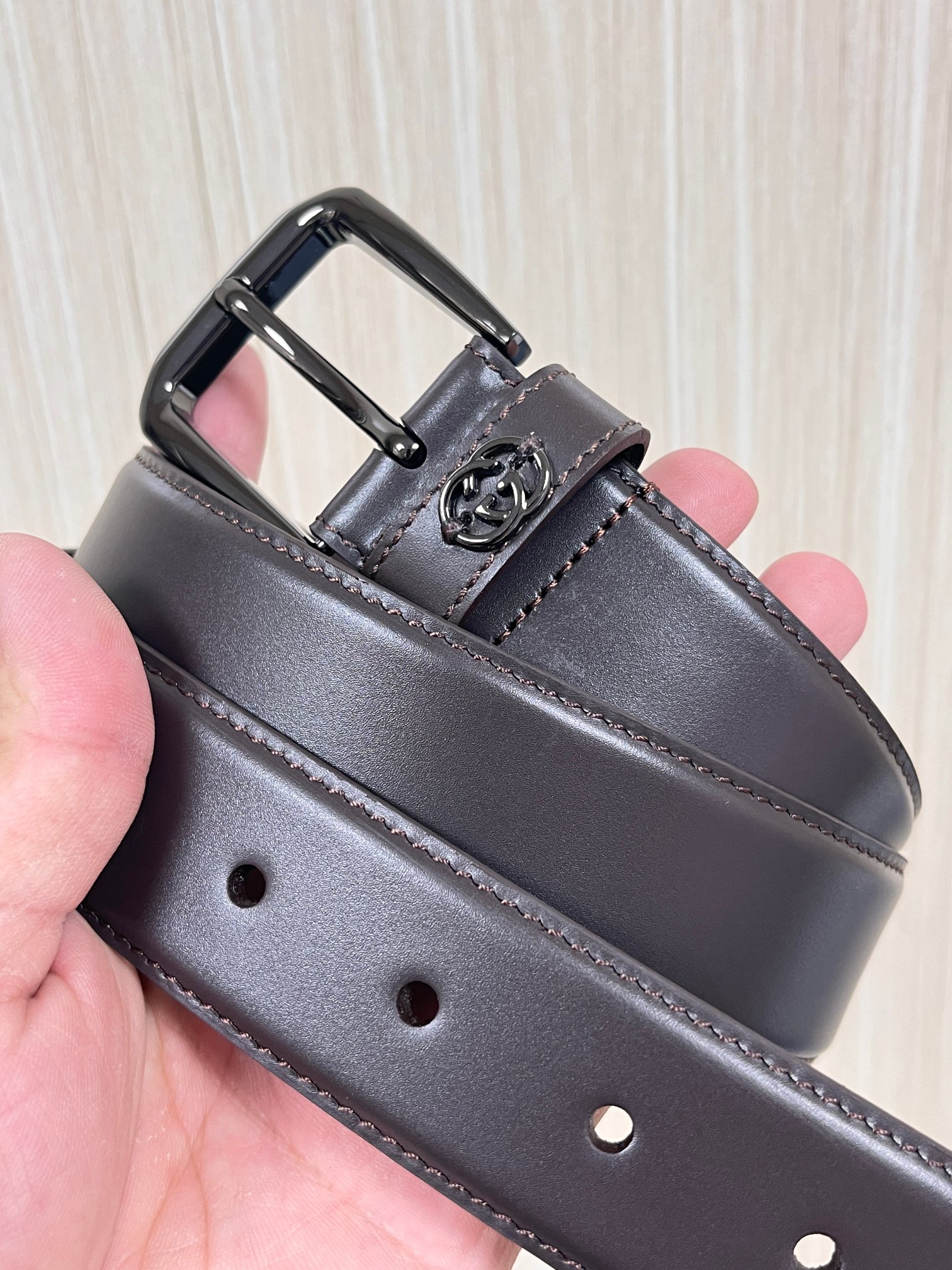 当季新款，中性色调精致牛皮革与方形搭扣完美合璧，不经意间散发商务正装风范。这款宽版腰带精选光面牛皮革制作