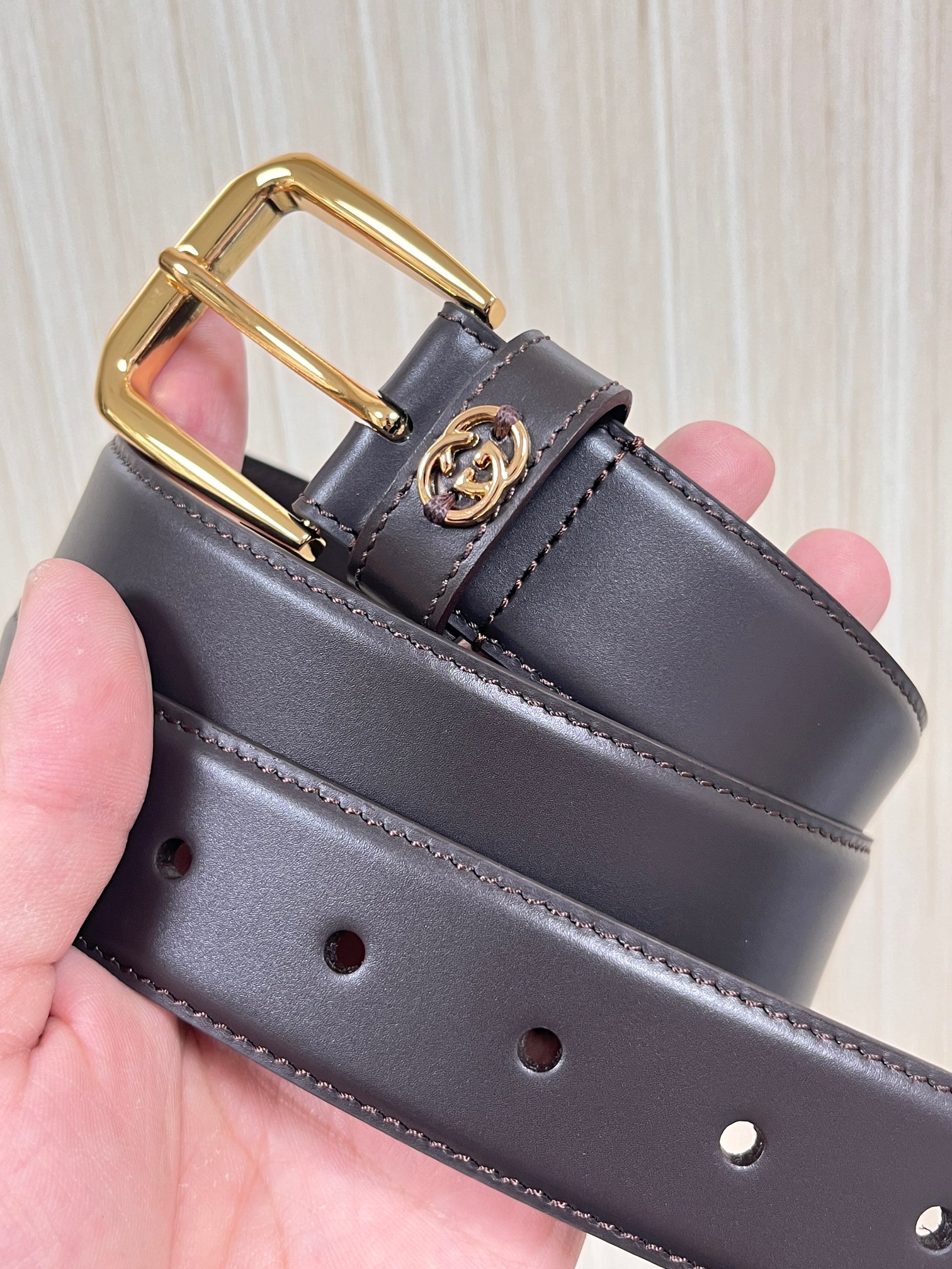 当季新款，中性色调精致牛皮革与方形搭扣完美合璧，不经意间散发商务正装风范。这款宽版腰带精选光面牛皮革制作