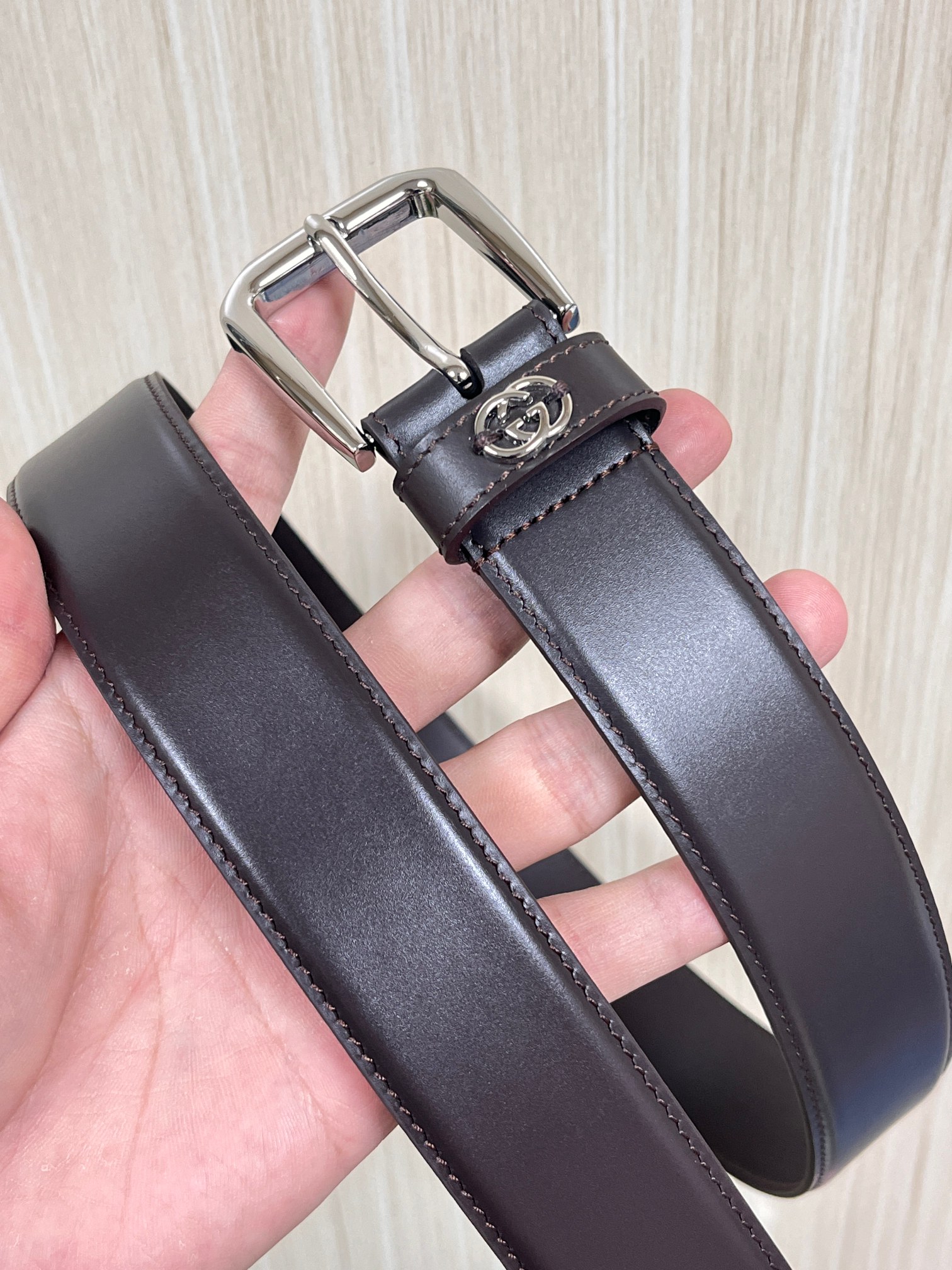 当季新款，中性色调精致牛皮革与方形搭扣完美合璧，不经意间散发商务正装风范。这款宽版腰带精选光面牛皮革制作