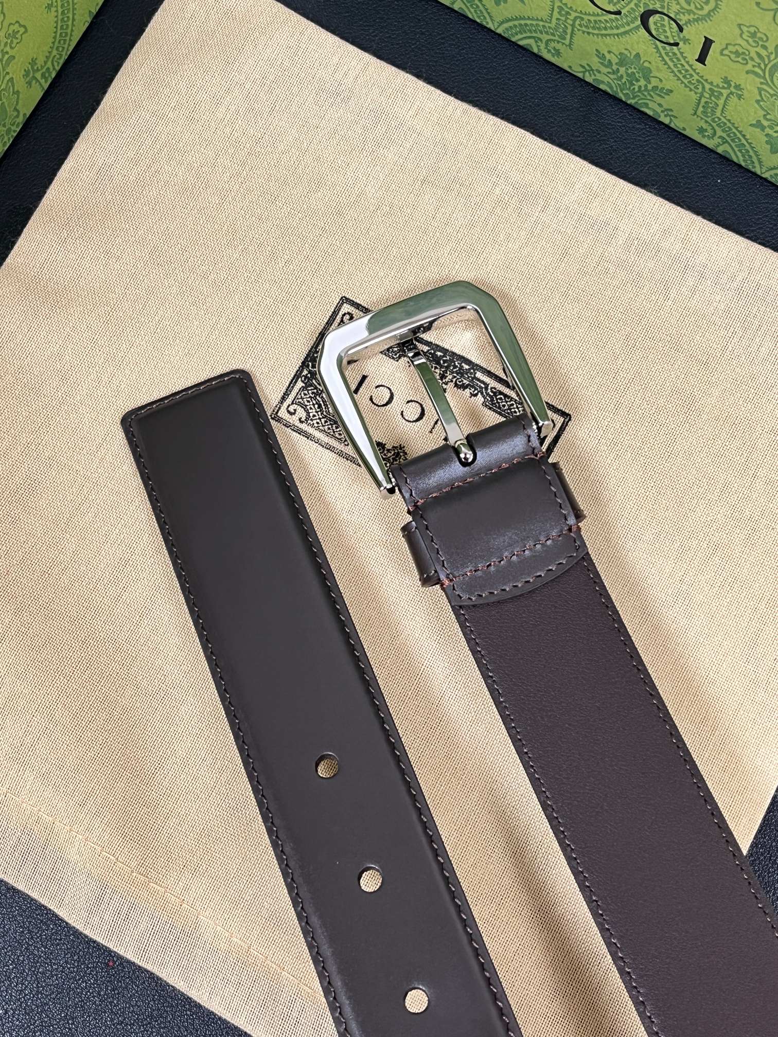 当季新款，中性色调精致牛皮革与方形搭扣完美合璧，不经意间散发商务正装风范。这款宽版腰带精选光面牛皮革制作