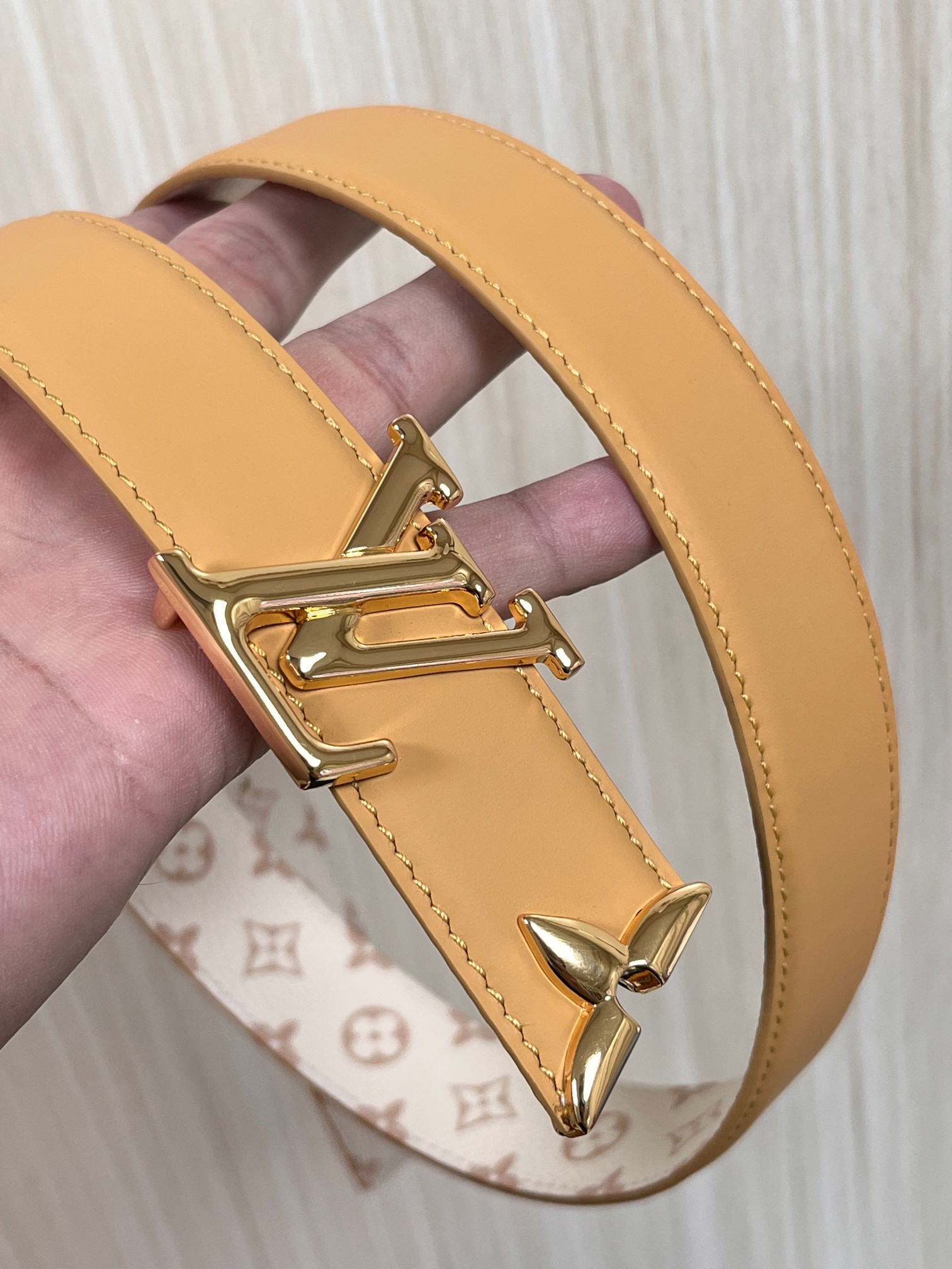 当季新款是一款专为女士设计的经典配饰。一面是标志性的 Monogram 帆布（白/米色调老花），另一面是