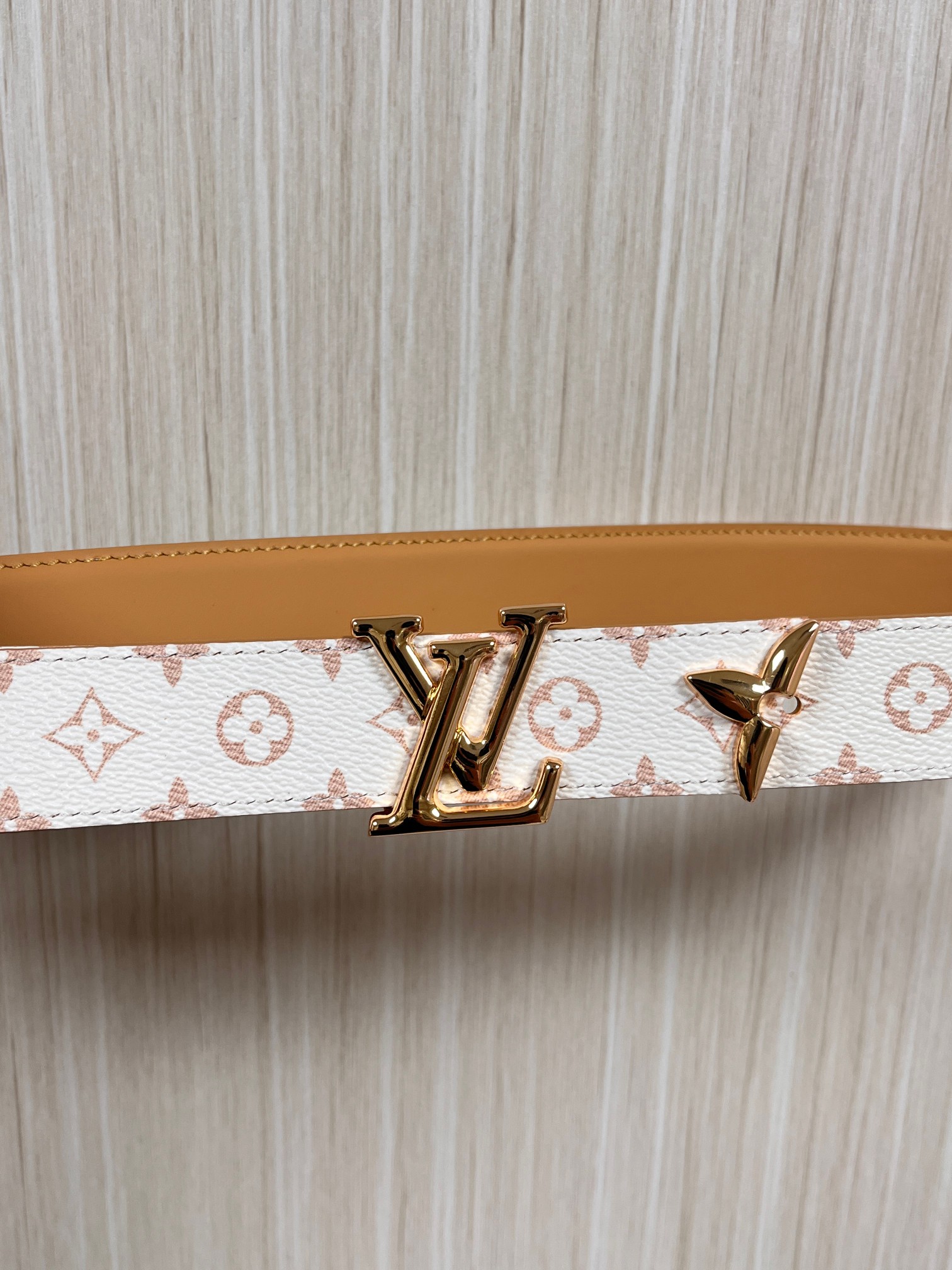 当季新款是一款专为女士设计的经典配饰。一面是标志性的 Monogram 帆布（白/米色调老花），另一面是