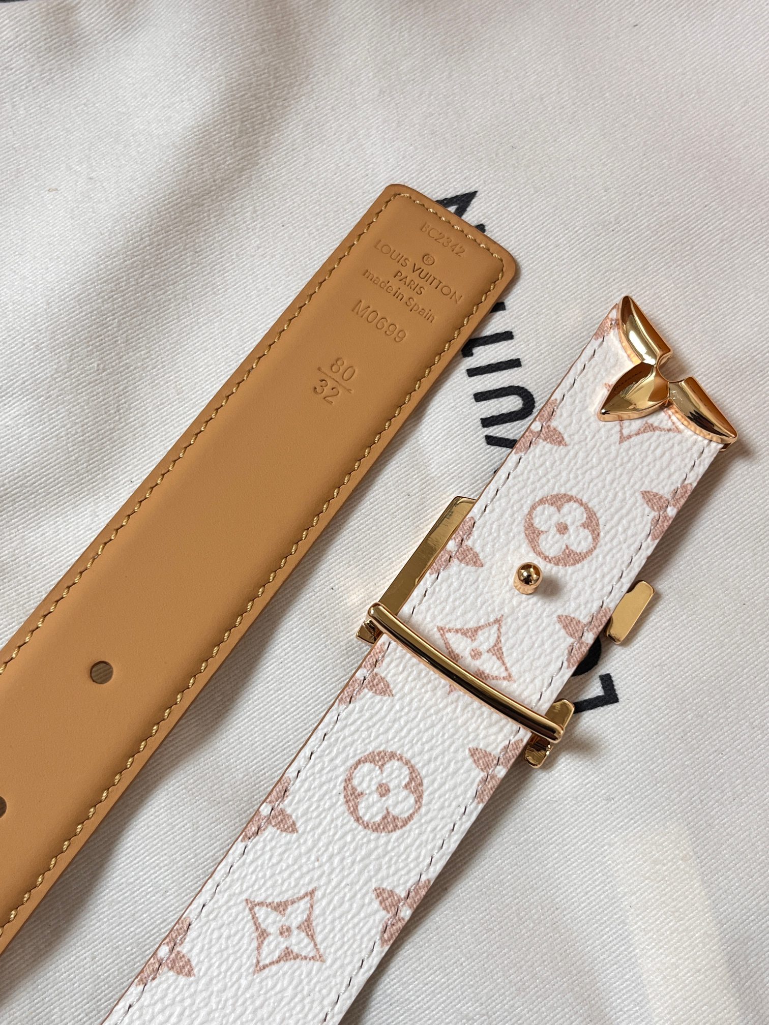 当季新款是一款专为女士设计的经典配饰。一面是标志性的 Monogram 帆布（白/米色调老花），另一面是