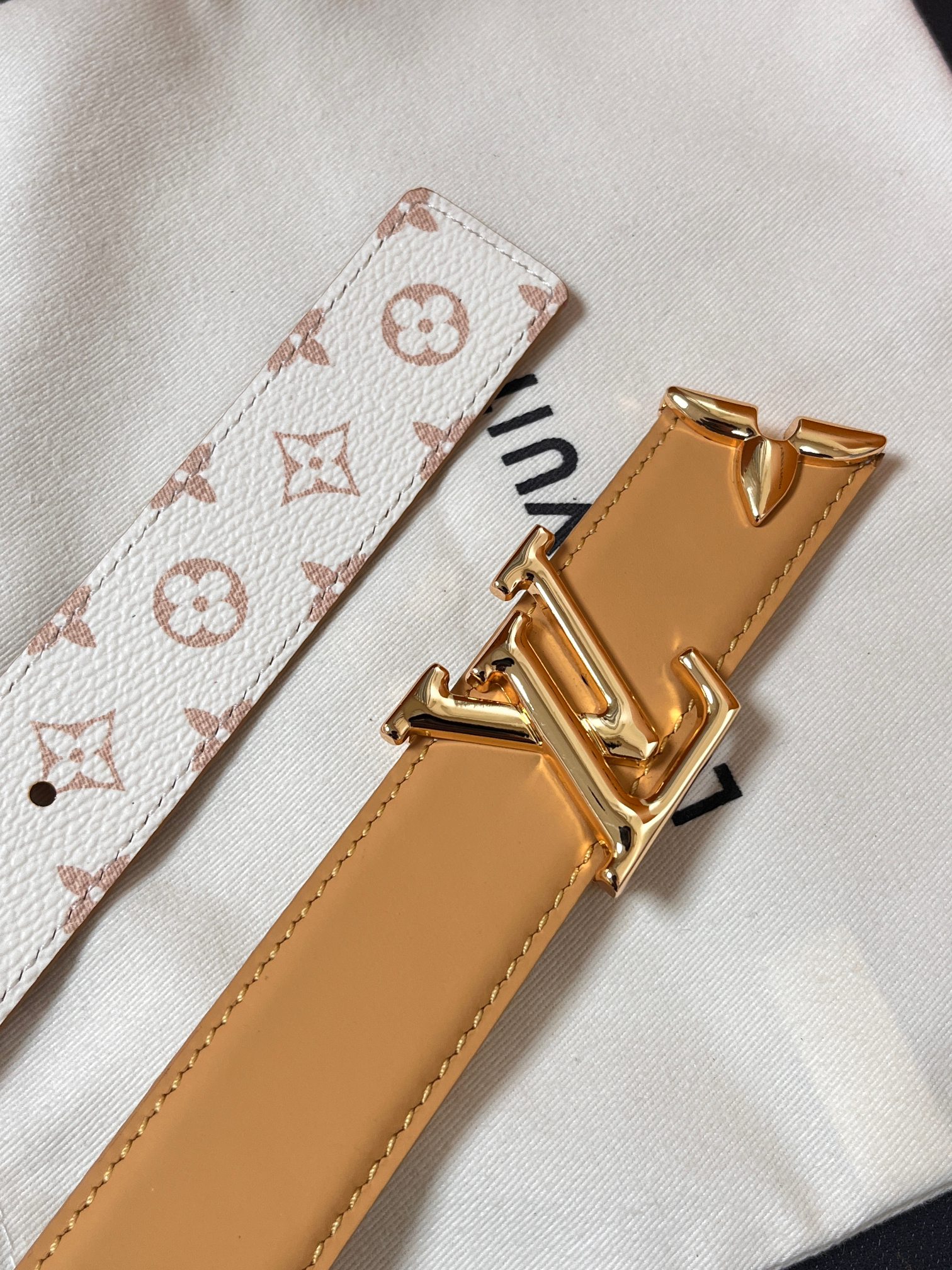 当季新款是一款专为女士设计的经典配饰。一面是标志性的 Monogram 帆布（白/米色调老花），另一面是