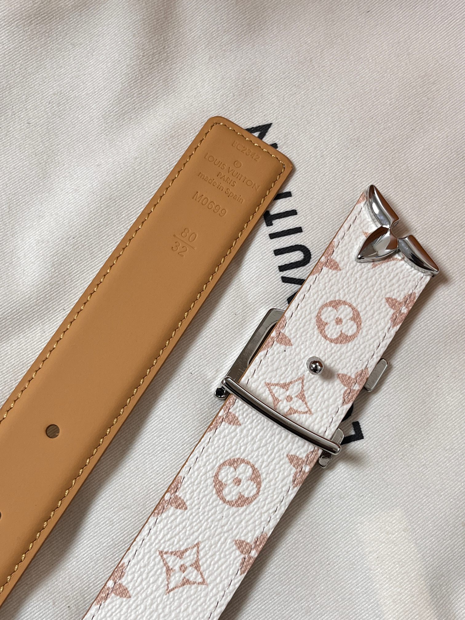 当季新款是一款专为女士设计的经典配饰。一面是标志性的 Monogram 帆布（白/米色调老花），另一面是