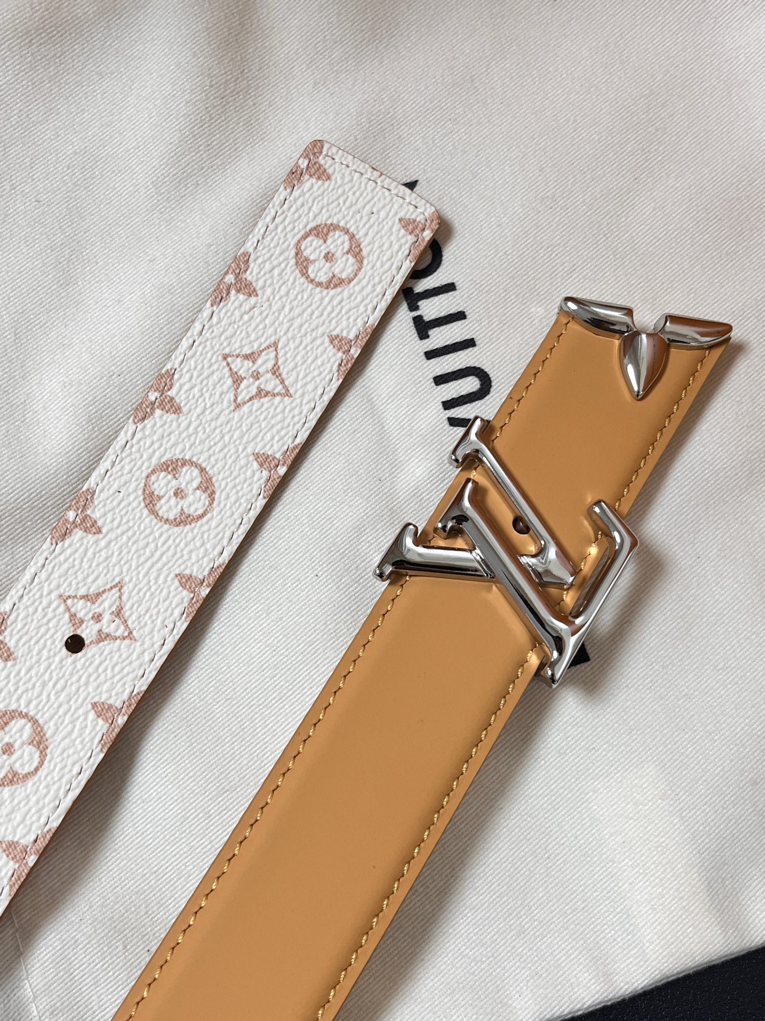 当季新款是一款专为女士设计的经典配饰。一面是标志性的 Monogram 帆布（白/米色调老花），另一面是