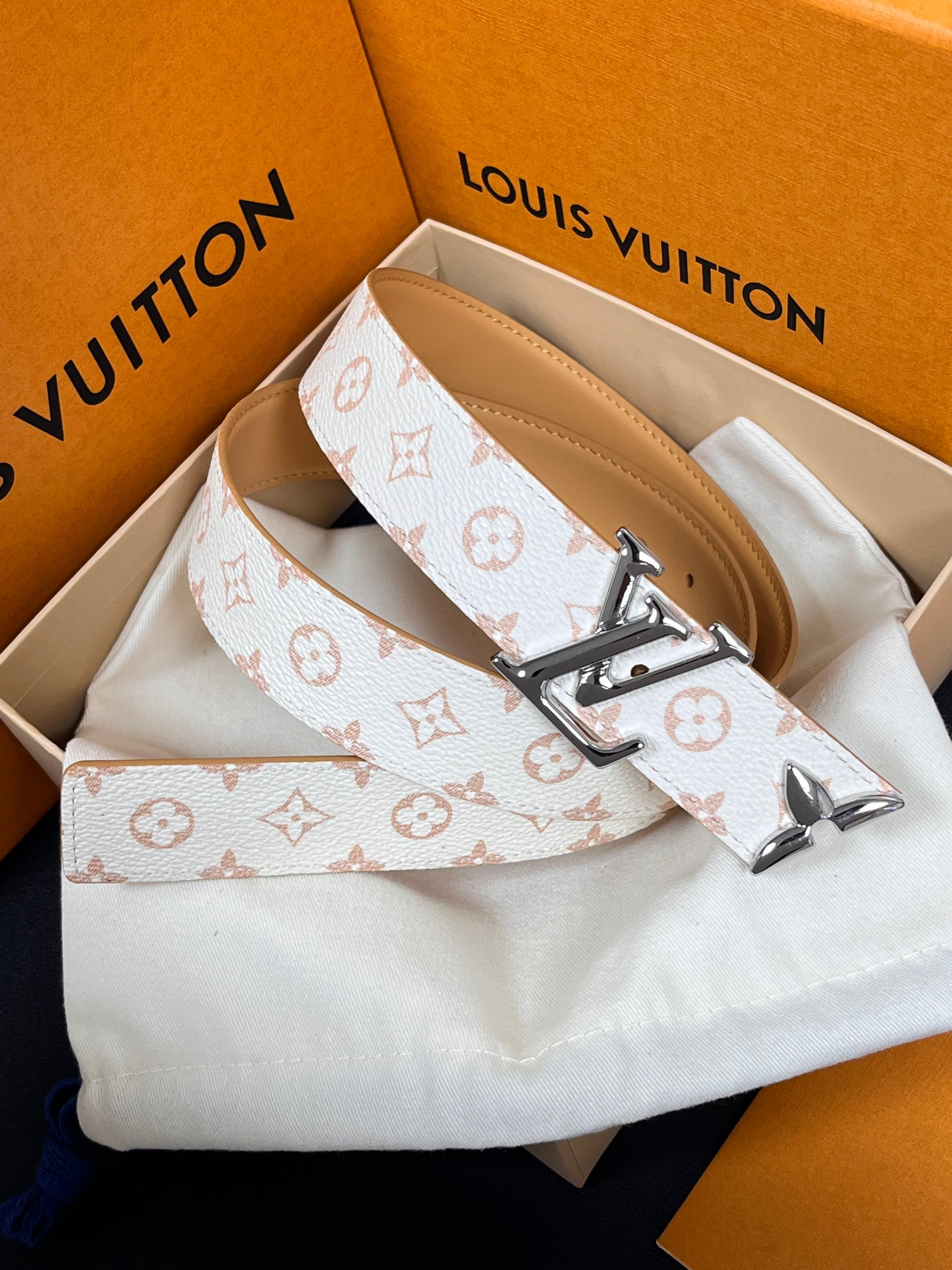 当季新款是一款专为女士设计的经典配饰。一面是标志性的 Monogram 帆布（白/米色调老花），另一面是