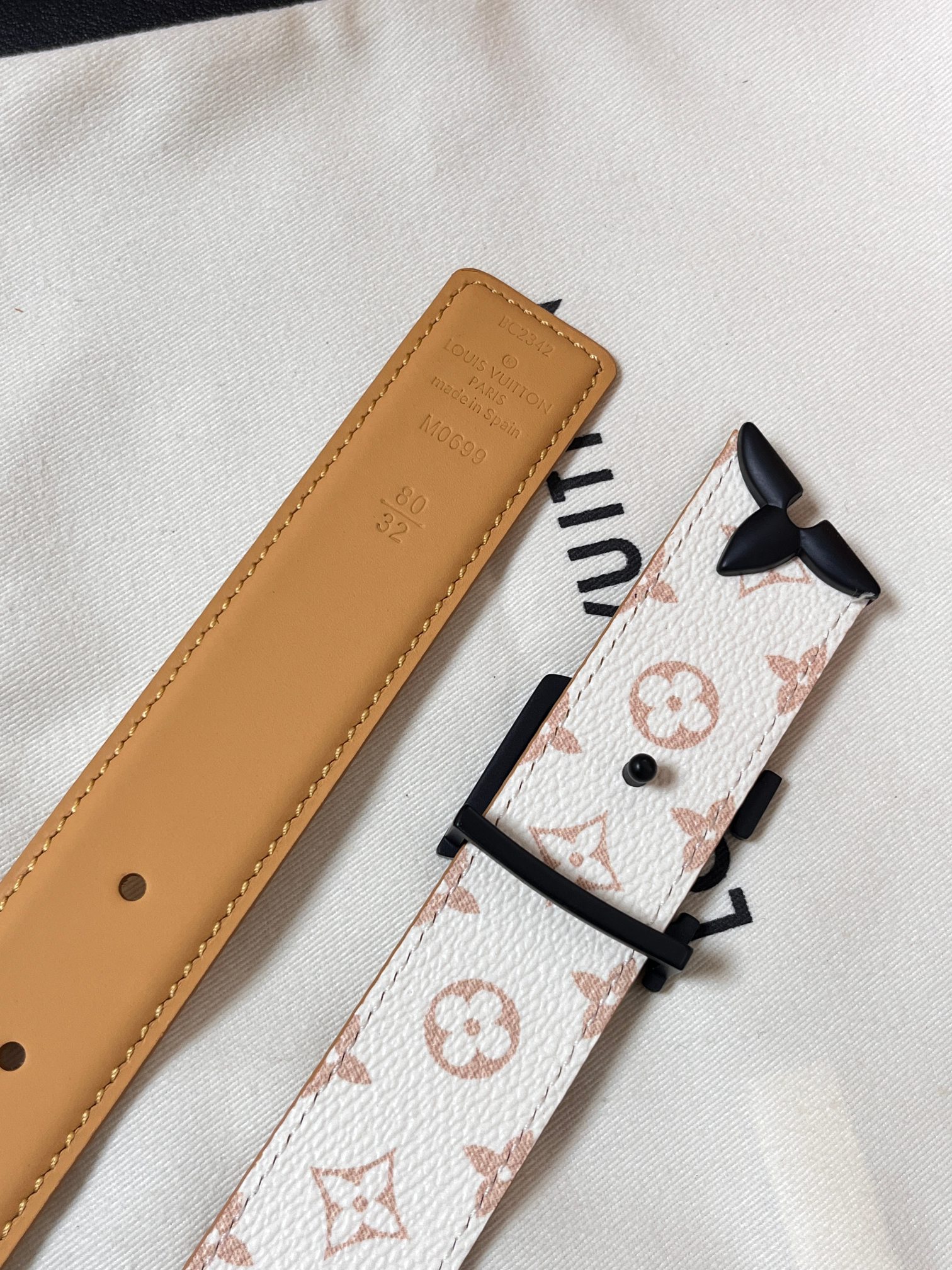 当季新款是一款专为女士设计的经典配饰。一面是标志性的 Monogram 帆布（白/米色调老花），另一面是