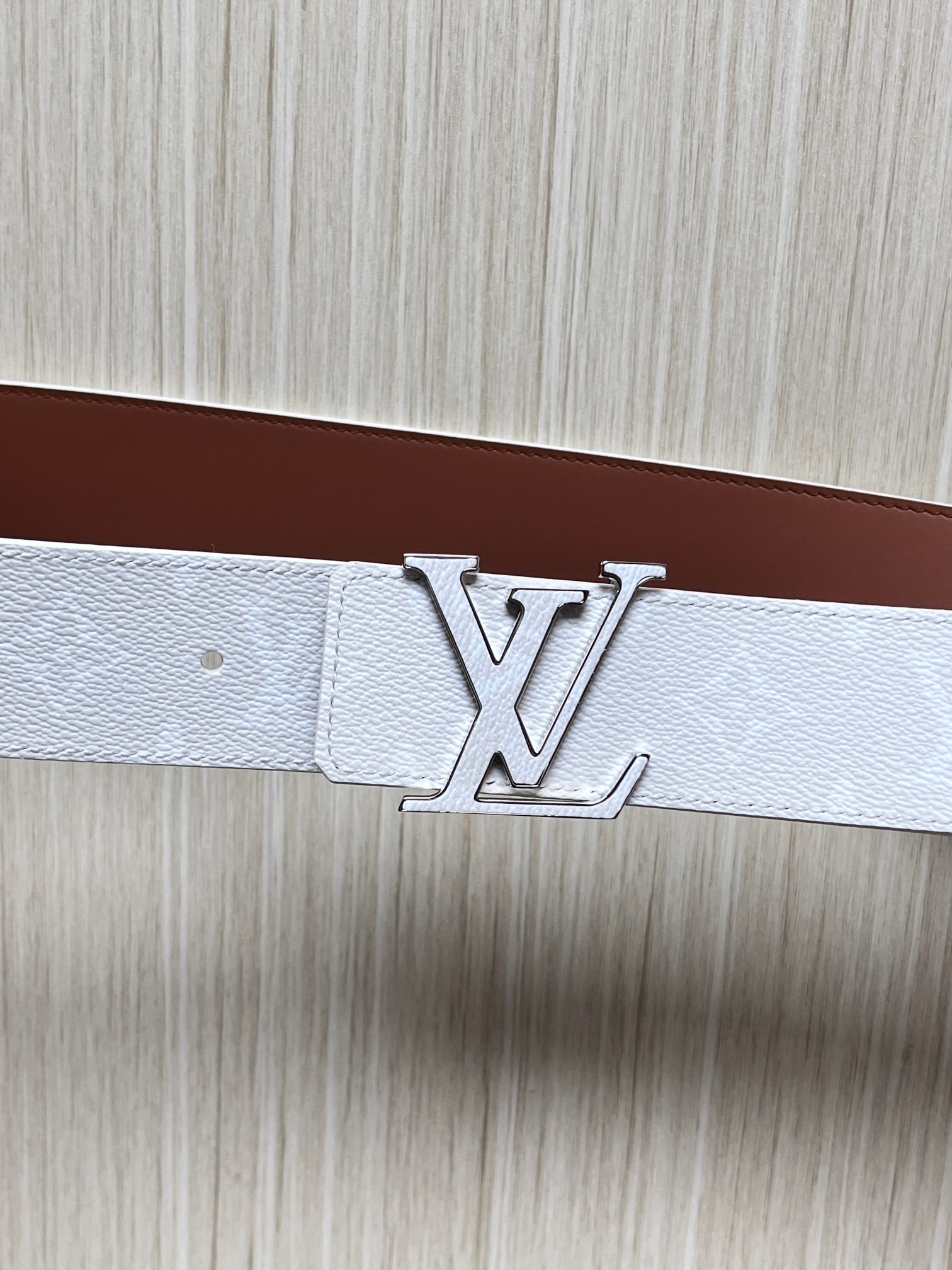 当季新款正面：Monogram涂层帆布，带有特殊反光处理，LV经典老花标识在光线照射下会呈现低调的闪耀效果，图中为白棕配