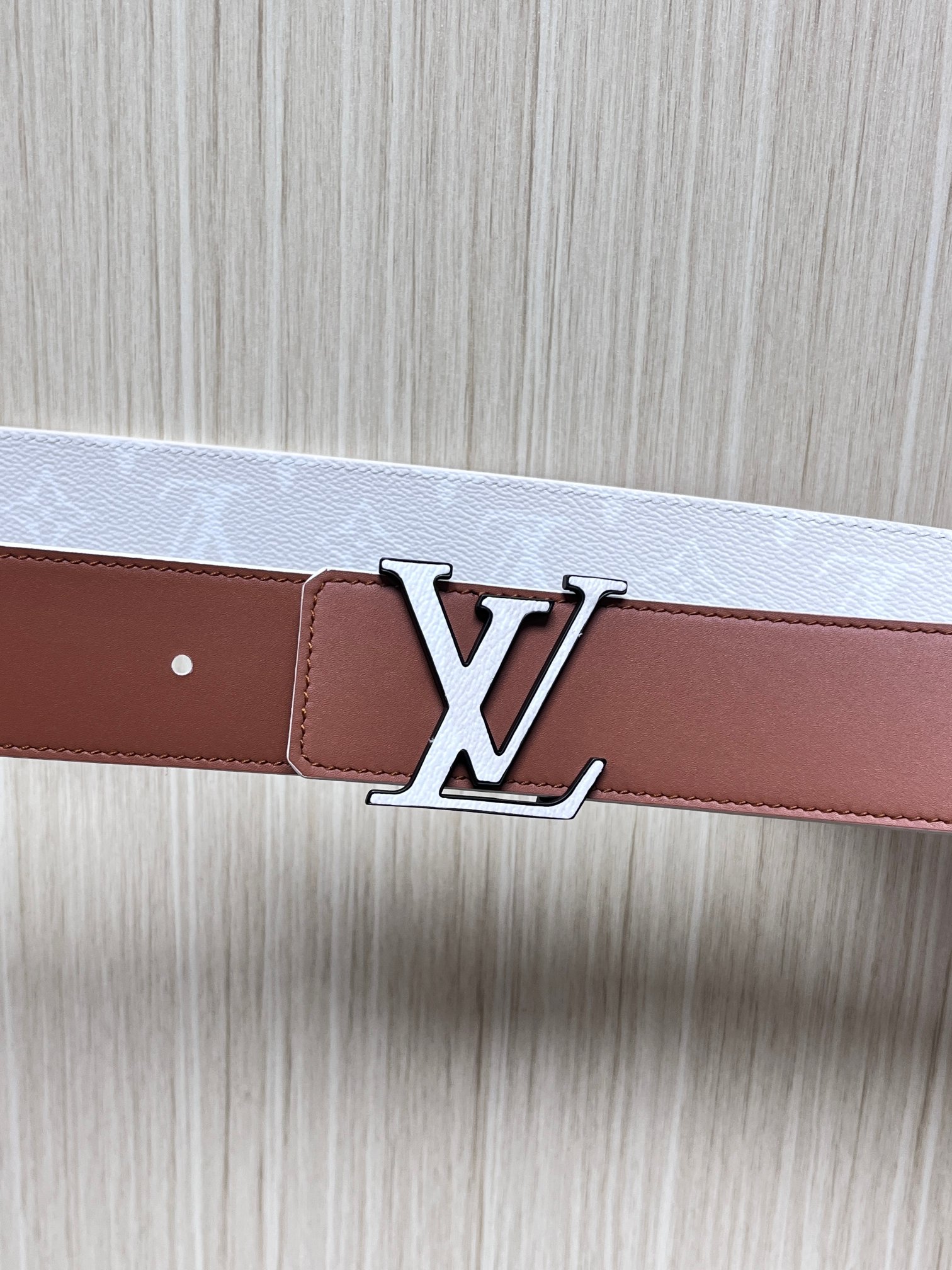 当季新款正面：Monogram涂层帆布，带有特殊反光处理，LV经典老花标识在光线照射下会呈现低调的闪耀效果，图中为白棕配