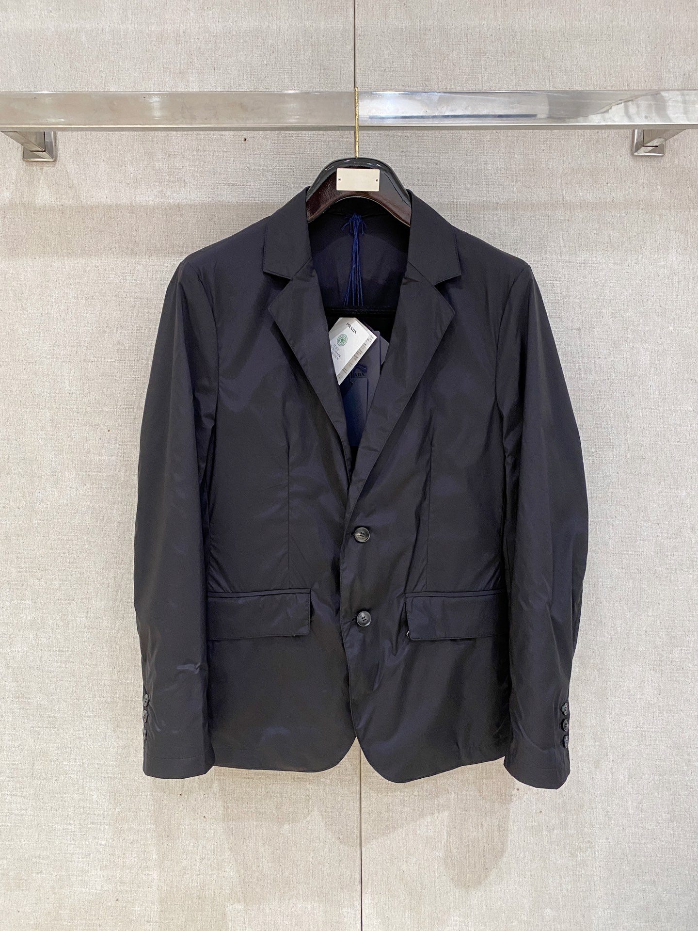 NO:538094,PRADA single-breasted thin cotton nylon suit, a timeless symphony of classic and innovation - in the name of craftsmanship, this Re-Nylon jacket outlines the body shape with excellent tailoring, perfectly blending the elegant genes of the classic suit with the modern edge of nylon. It uses the brand's iconic Re-Nylon recycled nylon fabric, which combines light texture and excellent performance. This innovative material not only continues PRADA's adherence to environmental protection concepts, but also uses a delicate touch and a crisp silhouette to give the jacket an elegant drapery like a suit, but also has a nylon waterproof and windproof characteristics.  The fine lines, the fitting tailor is precisely fitted with the body curve, cleverly modify the proportions, the flat collar design is classic without losing the sense of strength, and the details of the rear slit release agility while walking. The double-button closure design uses simple lines to outline the sense of ceremony, and matches the three-button loose-leaf cuffs. The details show the tribute and innovation of the traditional suit craftsmanship. The flip-in pockets on both sides are outlined with neat lines, and the classic design takes into account both practicality and decorativeness. The metal zipper closure is hidden under the flip, and the brand engraved letters on the zipper sheet are engraved. The PRADA MILANO letters on the buttons are engraved. The ultimate pursuit of delicate touch is consistent with the fabric lining, thin cotton filling, warm and comfortable. Color black Size M-3XL (48-56), prada, jackets & coats, business  suit,alexander wang19860909PRADA单排扣薄棉尼龙西服,经典与创新的永恒交响——以匠艺之名,这款Re-Nylon夹克,它以卓越剪裁勾勒身形轮廓,将经典西装的典雅基因与尼龙的现代锋芒完美交融. 采用品牌标志性Re-Nylon再生尼龙面料,兼具轻盈质感与卓越性能.这种创新材质不仅延续PRADA对环保理念的坚守,更以细腻触感和挺括廓形,赋予夹克如西装般的优雅垂坠,又不失尼龙的防水防风特性. 精裁线条,合身剪裁精准贴合身形曲线,巧妙修饰比例,平驳领设计经典而不失力量感,后开衩细节在行走间释放灵动韵律.双纽扣开合设计,以简洁线条勾勒仪式感,搭配三纽扣活页袖口,细节之处彰显对传统西装工艺的致敬与革新. 两侧翻盖嵌线袋以利落线条勾勒,经典设计兼顾实用与装饰性.而翻盖之下暗藏金属拉链开合,拉链片上的品牌攥刻字母.纽扣上的PRADA MILANO字母攥刻.同面料衬里表里如一的极致追求触感细腻,薄棉填充 保暖舒适. 颜色黑色 尺码M-3XL（48-56）,,prada,jackets & coats,business suit,alexander wang,Men's clothing