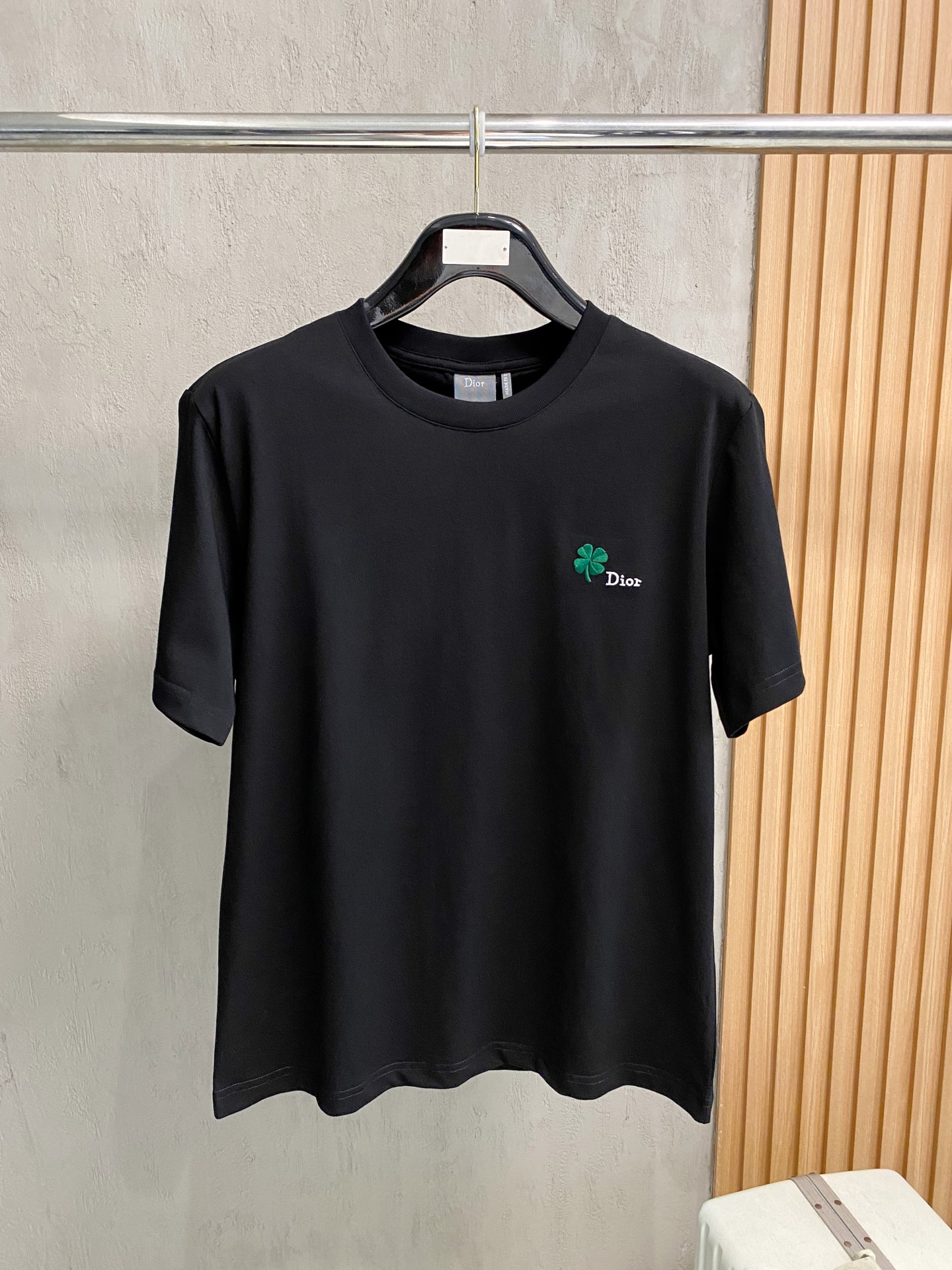 NO:947311,Dior 2026ss round neck four-leaf clover embroidered graphic T-shirt  ●Description: This black short-sleeved T-shirt is made of high-count double-ply combed cotton blend fabric. The neckline is made of high-elastic ribbing with three-needle hemming technology, which is not easy to loosen and curl after repeated wear. The side seams of the body are made of double-needle embedded clip technology, which ensures smooth and firm routing and reduces skin friction. The green clover pattern distributed on the body is made of precision  Embroidery technology, the stitches are fine and even, the pattern is three-dimensional and full and not easy to get off-line; the ready-made garments undergo multiple quality inspection processes such as stitching, ironing, and decontamination. The version is loose and moderate, suitable for daily leisure, dating and travel and other scenarios, with both exquisite details and practical wearability. The overall wiring is straight and delicate, the fabric is comfortable and soft, and the colors are consistent without color difference.  It can be matched with the same style to create a fashionable look, and can be used in various occasions. Customized accessories, complete with three standards, same style for men and women!  Size S-2XL,,dior,T-shirt,tees,t-shirt,19860909Dior 2026ss圆领四叶草刺绣图案T恤 ●描述这款黑色短袖T恤采用高支双股精梳棉混纺面料,领口采用高弹力罗纹搭配三本针包边工艺,反复穿着不易松弛卷边；衣身侧缝采用双针埋夹工艺,走线平整牢固,减少皮肤摩擦感.衣身分布的绿色三叶草图案采用精密刺绣工艺,针脚细密均匀,图案立体饱满且不易脱线；成衣经针、整烫、去污等多道质检工序,版型宽松有度,适配日常休闲、约会出游等多种场景,兼具精致细节与实穿性.整体走线平直细腻,面料舒适柔软,颜色一致无色差 能与同款搭配营造时尚造型,驾驭各种场合,定制辅料,三标齐全,男女同款！ 尺码S-2XL,,dior,T-shirt,tees，t-shirt,,Men's clothing