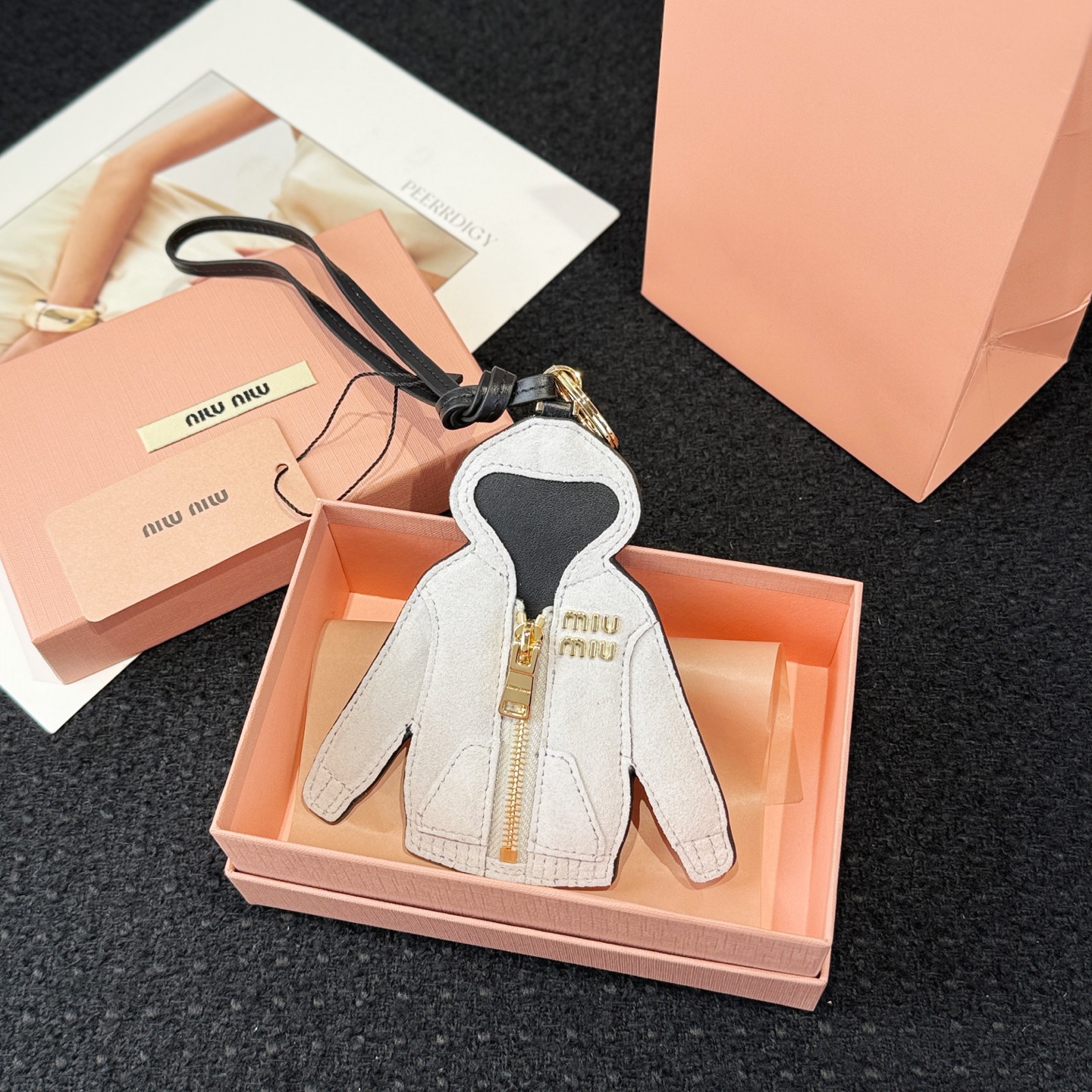 NO:617230,New product - MIUMIU Miu Miu leather air layer jacket lanyard pendant - Comes with the original packaging as shown in the picture - Miu Miu wardrobe essentials are transformed into precious pendants that can be matched with handbags to create a unique look. This leather keychain is shaped like a classic hoodie, symbolizing individuality and exploration spirit.,,miumiu,jackets & coats,keychain,hats19860909新品 -MIUMIU缪缪皮革空气层外套挂绳挂件 -配图片原版包装 -Miu Miu衣橱必备单品化身为珍贵挂饰,可与手袋搭配,打造别致造型.这款皮革钥匙扣以经典款帽衫为造型,象征个性与探索精神.,,miumiu,jackets & coats,keychain,hats,accessory