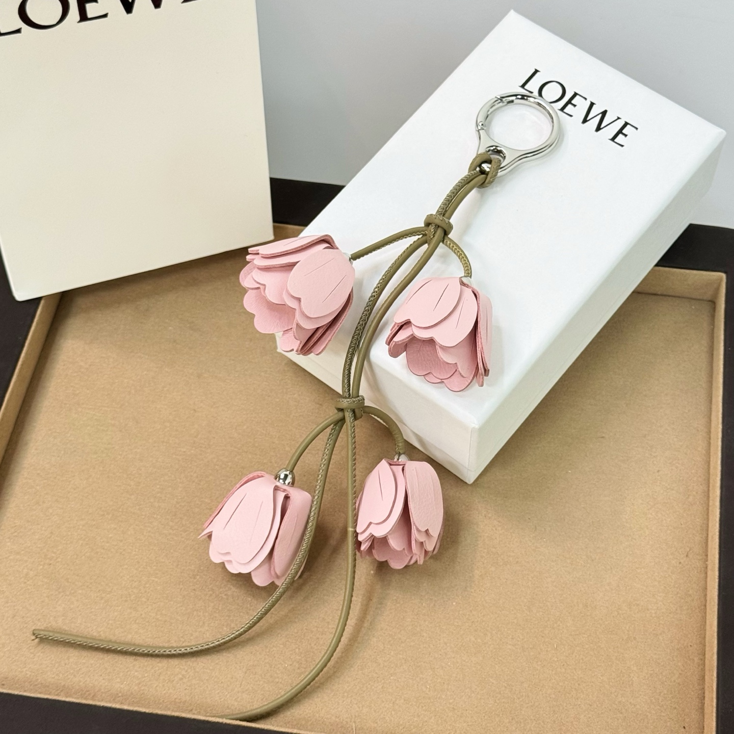 NO:811402,New product Loewe cherry blossom pendant/pendant with cow leather band and Anagram dice. The pendant is from the New Year series. Classic cow leather shape pendant, decorated with Anagram ebble dice and band. It can be hung on the bag. Its cute and cute shape makes people fall in love with it. loewe, loewe, cowhide19860909新品 罗意威Loewe 樱花挂饰/挂件 搭配牛皮革环带和 Anagram 骰子.挂饰为新春系列作品. 经典牛皮革造型挂饰,饰有Anagram ebble骰子和环带 可挂于包包,其萌趣、可爱的造型,让人爱不释手,,loewe,loewe,cowhide,accessory