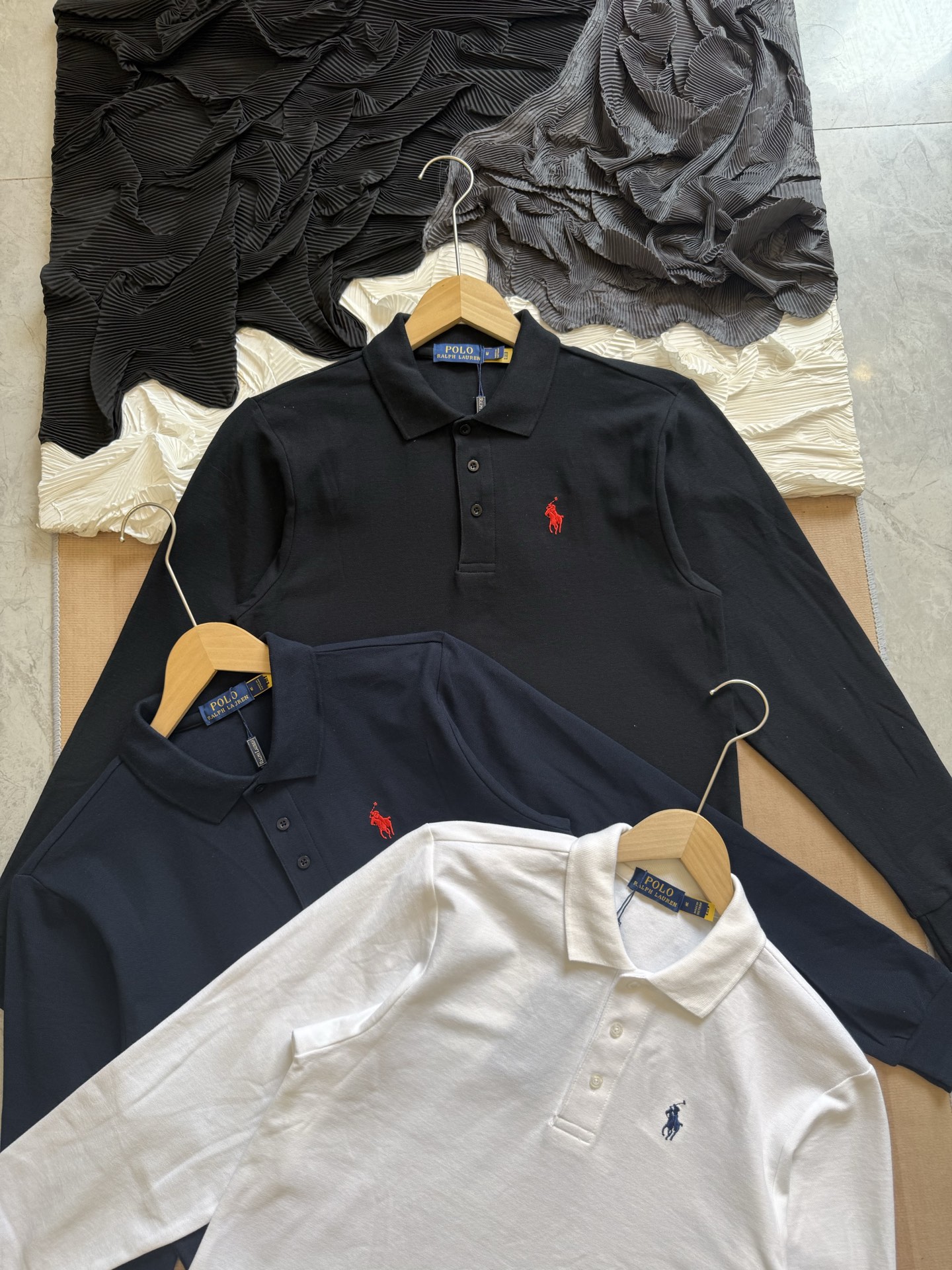 💰110
Ralph Lauren拉夫劳伦 三色经典小马刺绣 休闲基础款长袖Polo衫

采用高支数240g纯棉珠地布面料，透气不闷热，具备良好弹性与贴肤质感。无论是春夏单穿，还是秋冬内搭，都能保持干爽舒适，为日常穿搭增添轻盈体验。

每一处缝合均采用双线走针技术，牢固且耐穿。下摆采用双侧开叉设计，增强活动灵活度的同时不失版型利落。领口三粒扣设计，经典中带有变化，细节之处尽显品位。

胸前标志性Logo刺绣，黑色款搭配热烈红标，白色款搭配深蓝刺绣，凸显品牌辨识度的同时，又不失简洁大气。后领内衬带品牌织标，精致感满满。

经典色系，可正式可休闲，满足多种穿搭场景，修身剪裁，挺括有型，适合多种体型；
品牌象征 + 高品质工艺，体现穿着者的生活品位与审美高度，不止是一件Polo衫，更是日常中的质感表达。

-颜色：黑色、白色、藏青
-尺码：S-2XL

尺码   胸围  衣长  肩宽    推荐体重（斤）
 S       108     66     47     100-115
 M       112     69     48     115-130
 L        116     72      50     130-150
 XL      120     75      51     150-175
 XXL    124     78     53      175-205