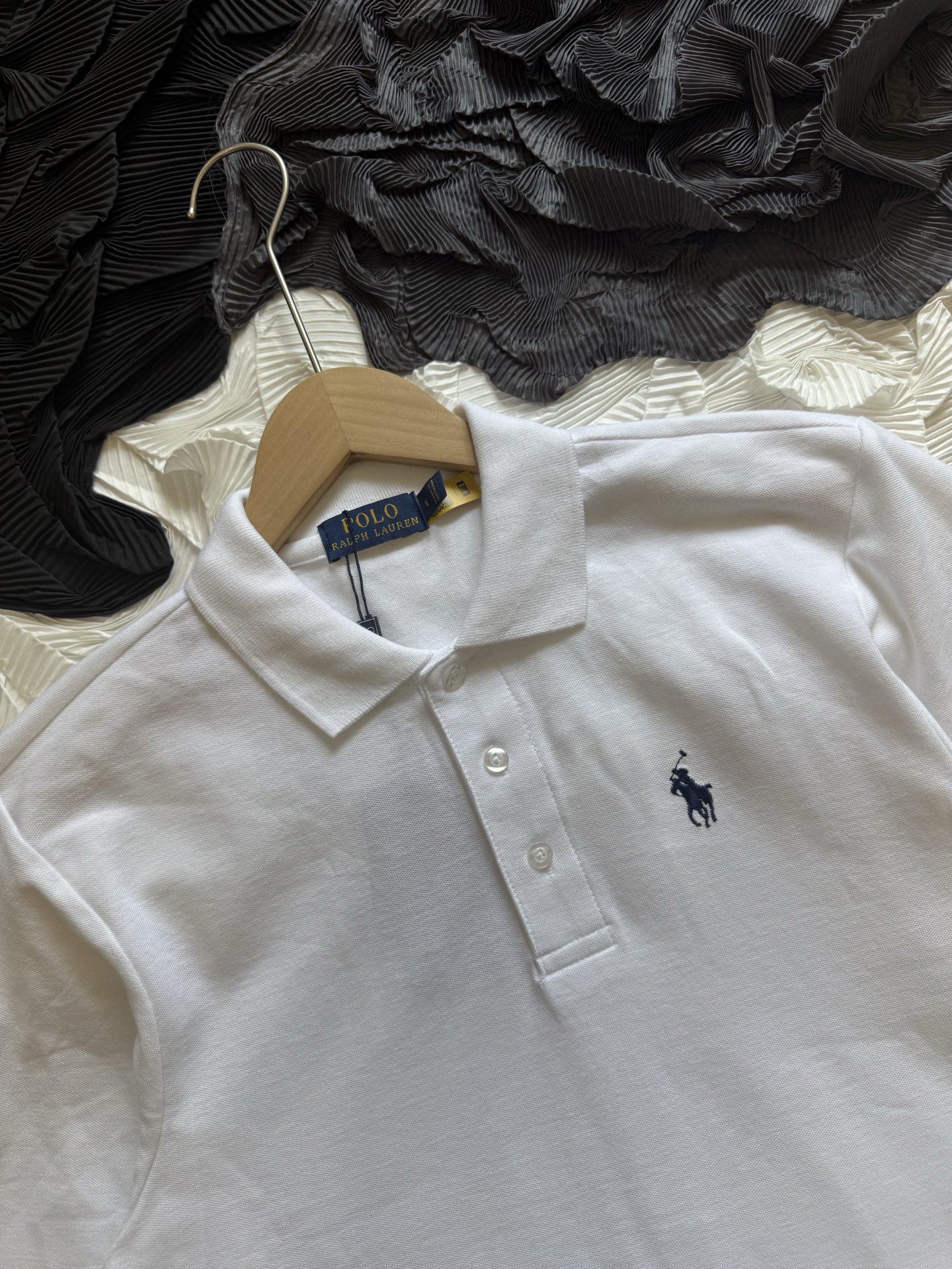 💰110
Ralph Lauren拉夫劳伦 三色经典小马刺绣 休闲基础款长袖Polo衫

采用高支数240g纯棉珠地布面料，透气不闷热，具备良好弹性与贴肤质感。无论是春夏单穿，还是秋冬内搭，都能保持干爽舒适，为日常穿搭增添轻盈体验。

每一处缝合均采用双线走针技术，牢固且耐穿。下摆采用双侧开叉设计，增强活动灵活度的同时不失版型利落。领口三粒扣设计，经典中带有变化，细节之处尽显品位。

胸前标志性Logo刺绣，黑色款搭配热烈红标，白色款搭配深蓝刺绣，凸显品牌辨识度的同时，又不失简洁大气。后领内衬带品牌织标，精致感满满。

经典色系，可正式可休闲，满足多种穿搭场景，修身剪裁，挺括有型，适合多种体型；
品牌象征 + 高品质工艺，体现穿着者的生活品位与审美高度，不止是一件Polo衫，更是日常中的质感表达。

-颜色：黑色、白色、藏青
-尺码：S-2XL

尺码   胸围  衣长  肩宽    推荐体重（斤）
 S       108     66     47     100-115
 M       112     69     48     115-130
 L        116     72      50     130-150
 XL      120     75      51     150-175
 XXL    124     78     53      175-205