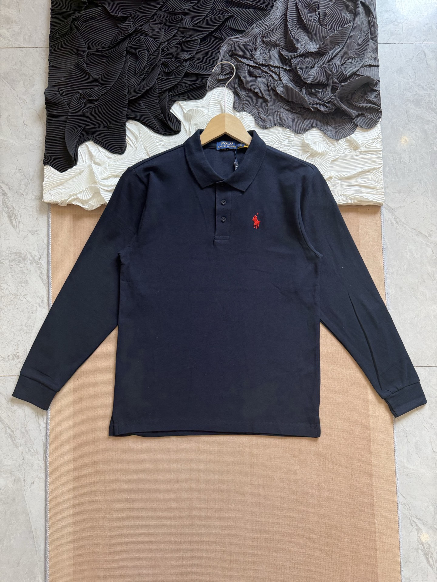 💰110
Ralph Lauren拉夫劳伦 三色经典小马刺绣 休闲基础款长袖Polo衫

采用高支数240g纯棉珠地布面料，透气不闷热，具备良好弹性与贴肤质感。无论是春夏单穿，还是秋冬内搭，都能保持干爽舒适，为日常穿搭增添轻盈体验。

每一处缝合均采用双线走针技术，牢固且耐穿。下摆采用双侧开叉设计，增强活动灵活度的同时不失版型利落。领口三粒扣设计，经典中带有变化，细节之处尽显品位。

胸前标志性Logo刺绣，黑色款搭配热烈红标，白色款搭配深蓝刺绣，凸显品牌辨识度的同时，又不失简洁大气。后领内衬带品牌织标，精致感满满。

经典色系，可正式可休闲，满足多种穿搭场景，修身剪裁，挺括有型，适合多种体型；
品牌象征 + 高品质工艺，体现穿着者的生活品位与审美高度，不止是一件Polo衫，更是日常中的质感表达。

-颜色：黑色、白色、藏青
-尺码：S-2XL

尺码   胸围  衣长  肩宽    推荐体重（斤）
 S       108     66     47     100-115
 M       112     69     48     115-130
 L        116     72      50     130-150
 XL      120     75      51     150-175
 XXL    124     78     53      175-205