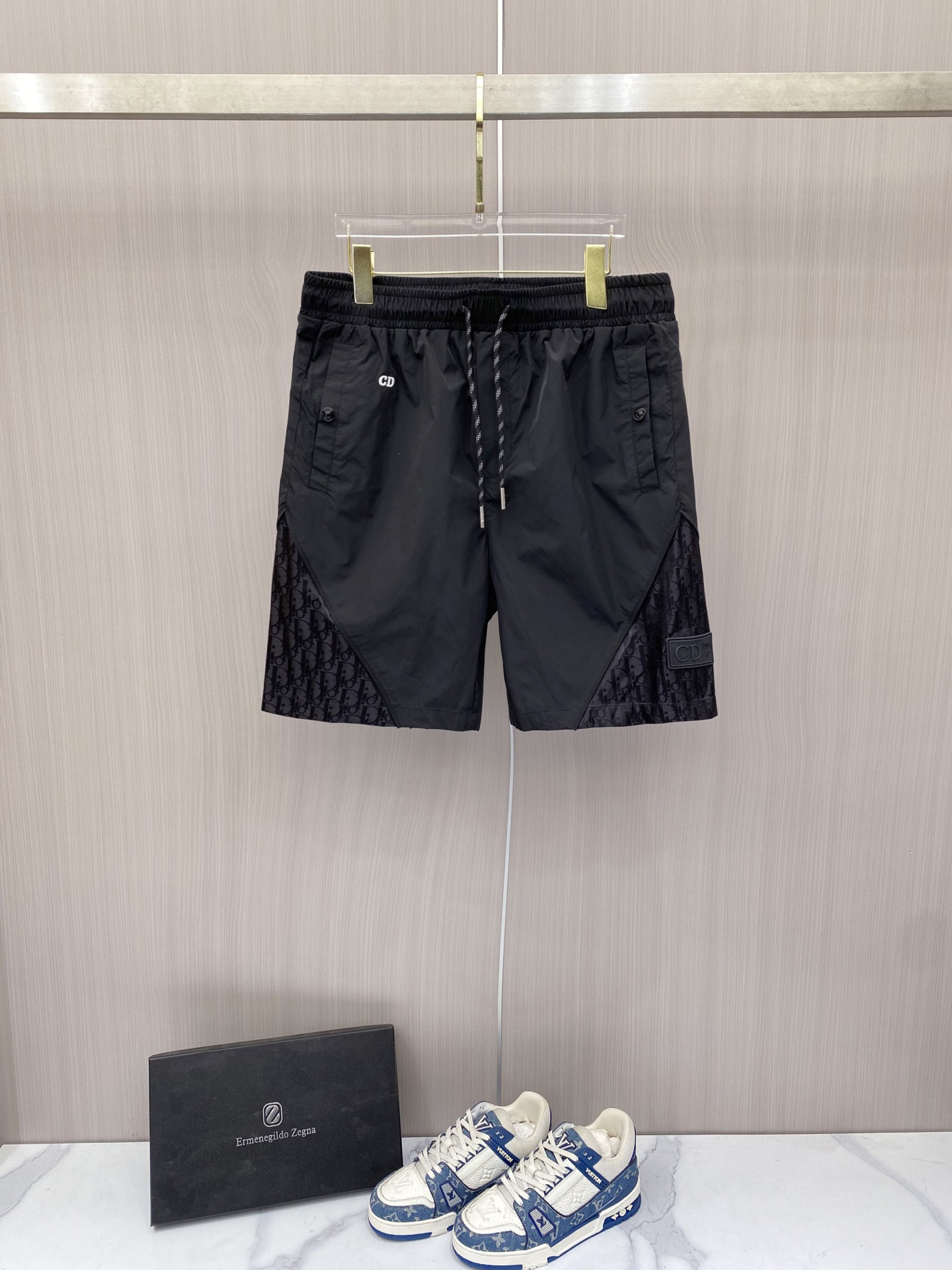 NO:848770,Dior Dior  2026ss summer Oblique presbyopic splicing series casual shorts, available in black/coffee colors, combine the brand's iconic elements with functional tailoring to create a new texture. Made of high-density anti-wrinkle nylon fabric, the upper body is light and breathable, with a smooth drape, without fear of summer heat and wrinkles; the waistband adopts a two-color drawstring elastic design  , with exquisite rope details, taking into account both comfort and sophistication. The Oblique presbyopia stitching on both sides of the pants, the HD logo on the front, and the three-dimensional DIOR patch pocket on the back are low-key to inject brand recognition. The neat straight silhouette modifies the leg shape. Whether it is daily life in the city or on vacation, you can easily wear a relaxed and noble summer style.  Color black coffee code number 48-56, dior, dior, shorts,19860909Dior 迪奥 2026ss夏季Oblique老花拼接系列休闲短裤,黑/咖双色可选,把品牌标志性元素与机能剪裁玩出了新质感.甄选高密抗皱锦纶面料打造,上身轻薄透气,自带顺滑垂坠感,无惧夏日闷热与褶皱；腰头采用双色抽绳松紧设计,搭配精致绳头细节,兼顾舒适与精致度.裤身两侧的Oblique老花拼接与正面HD标识、背面立体DIOR贴袋,低调注入品牌辨识度,利落直筒版型修饰腿型,无论是都市日常还是度假出行,都能轻松穿出松弛显贵的夏日格调. 颜色黑色 咖色 码数48-56,,dior,dior,shorts,,Men's clothing