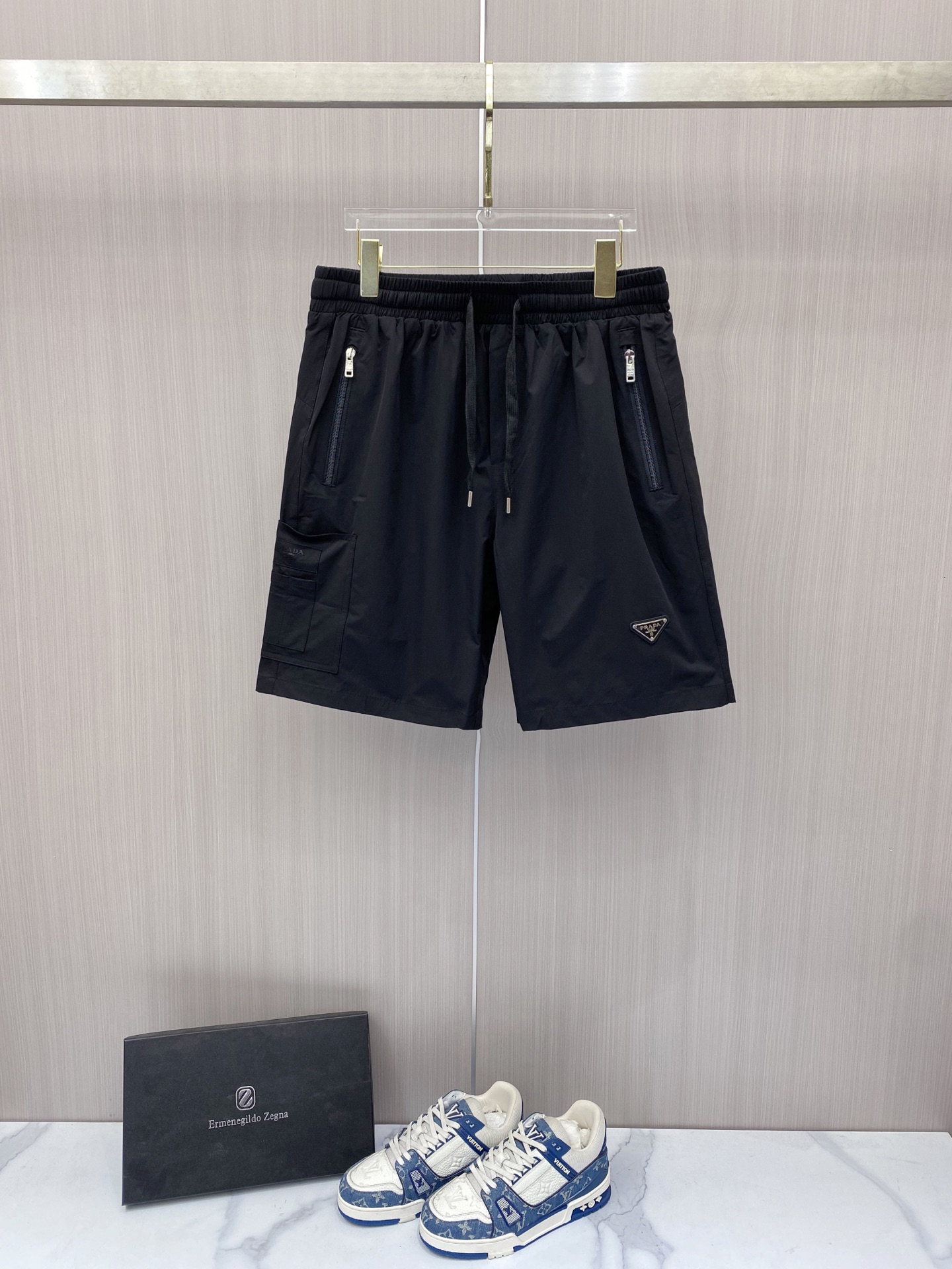 NO:848776,Prada Prada  2026ss summer classic triangle logo functional shorts, reconstructing summer casual aesthetics with minimalist lines. High-density anti-wrinkle nylon fabric is selected, which is smooth to the touch and has excellent breathability. It is light and burdenless to wear in summer; the elastic drawstring design at the waist is suitable for various body shapes and can be matched with  Equipped with double zipper side pockets and three-dimensional work patch pockets, the storage is full of security. The iconic enamel triangle logo on the front is the finishing touch, the webbing logo on the back has rigorous details, and the neat straight silhouette modifies the leg shape. Whether you are commuting in the city or traveling outdoors, you can easily create a high-end sense of relaxation.  Color Black White Size 48-56, prada, prada, shorts,19860909Prada 普拉达 2026ss夏季经典三角标机能短裤,以极简线条重构夏日休闲美学.甄选高密抗皱锦纶面料,触感顺滑且具备极佳透气性,夏日穿着轻盈无负担；腰头弹力抽绳设计适配各种身形,搭配双拉链侧袋与立体工装贴袋,收纳安全感拉满.正面标志性珐琅三角徽标点睛,背面织带标细节严谨,利落直筒版型修饰腿型,无论是都市通勤还是户外出行,皆能轻松演绎高阶松弛感. 颜色黑色 白色 码数48-56,,prada,prada,shorts,,Men's clothing