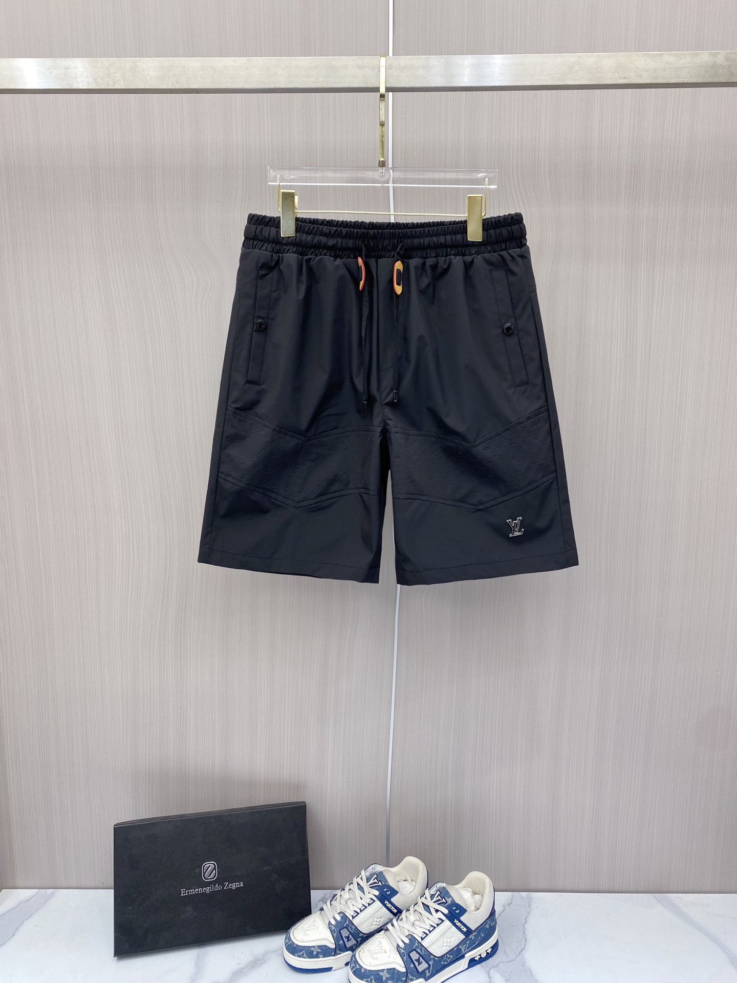 NO:848767,LV  2026ss summer limited functional casual shorts, which perfectly combine the brand's iconic Monogram dark pattern with modern tailoring. Made of high-density nylon fabric, which has both drape and breathability, and is not afraid of the sweltering summer heat; the waistband is designed with elastic drawstrings and contrasting color rope buckle points  The details are exquisite. The three-dimensional laminated pockets on the front and customized hardware buckles are both practical and recognizable. The metal LV logo on the trouser legs is a low-key statement. The neat straight silhouette is suitable for various scenes. Whether it is for vacation or daily wear, it can easily create a relaxed and high-quality style.  Color Black Beige Size 48-56, Louis Vuitton, shorts,19860909LV 2026ss夏季限定机能风休闲短裤,将品牌标志性Monogram暗纹与现代剪裁完美融合.甄选高密锦纶面料打造,兼具垂坠感与透气性,无惧夏日闷热；腰头采用松紧抽绳设计,搭配撞色绳扣点缀,细节尽显精致.前侧立体压胶口袋与定制五金扣兼具实用与辨识度,裤脚处的金属LV标识低调点题,利落直筒版型适配多元场景,无论是度假出行还是日常穿搭,都能轻松塑造松弛高级的质感格调. 颜色黑色 米色 码数48-56,,louis vuitton,shorts,,Men's clothing