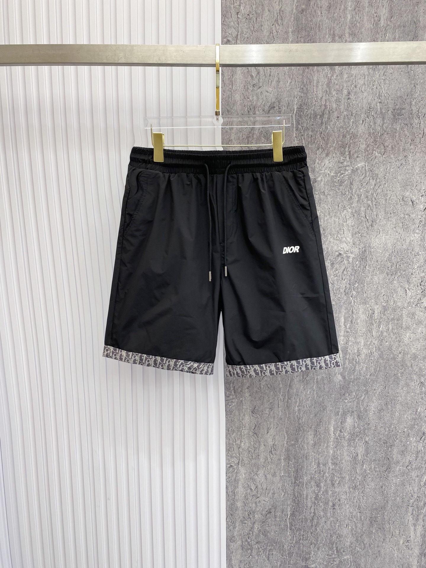 NO:842819,Dior Dior  The 2026ss summer limited edition Oblique presbyopic patchwork casual shorts cleverly combine the brand's iconic elements with modern functional tailoring. Made of high-density anti-wrinkle nylon fabric, the upper body is light and breathable, with a drapey texture, and is not afraid of the sweltering summer heat. The waistband is designed with elastic drawstrings and metal rope head details for comfort.  Comfortable and sophisticated; the iconic Oblique cuffing design on the legs of the trousers is a low-key way to inject brand recognition. It is matched with the eye-catching Dior letter logo on the front and the CD badge pocket on the back, and is full of details. The loose straight version modifies the leg shape, and can easily create a relaxed and high-quality style whether it is for vacation or daily wear.  Color Black Gray Size 48-56,,dior,dior,shorts,19860909Dior 迪奥 2026ss夏季限定Oblique老花拼接休闲短裤,将品牌标志性元素与现代机能剪裁巧妙融合.甄选高密抗皱尼龙面料打造,上身轻薄透气,自带垂坠质感,无惧夏日闷热.腰头采用松紧抽绳设计,搭配金属绳头细节,兼顾舒适与精致；裤脚标志性Oblique老花翻边设计,低调注入品牌辨识度,搭配正面醒目Dior字母标识与背面CD徽章口袋,细节拉满.宽松直筒版型修饰腿型,无论是度假出行还是日常穿搭,都能轻松塑造松弛高级的质感格调. 颜色黑色 灰色 码数48-56,,dior,dior,shorts,,Men's clothing