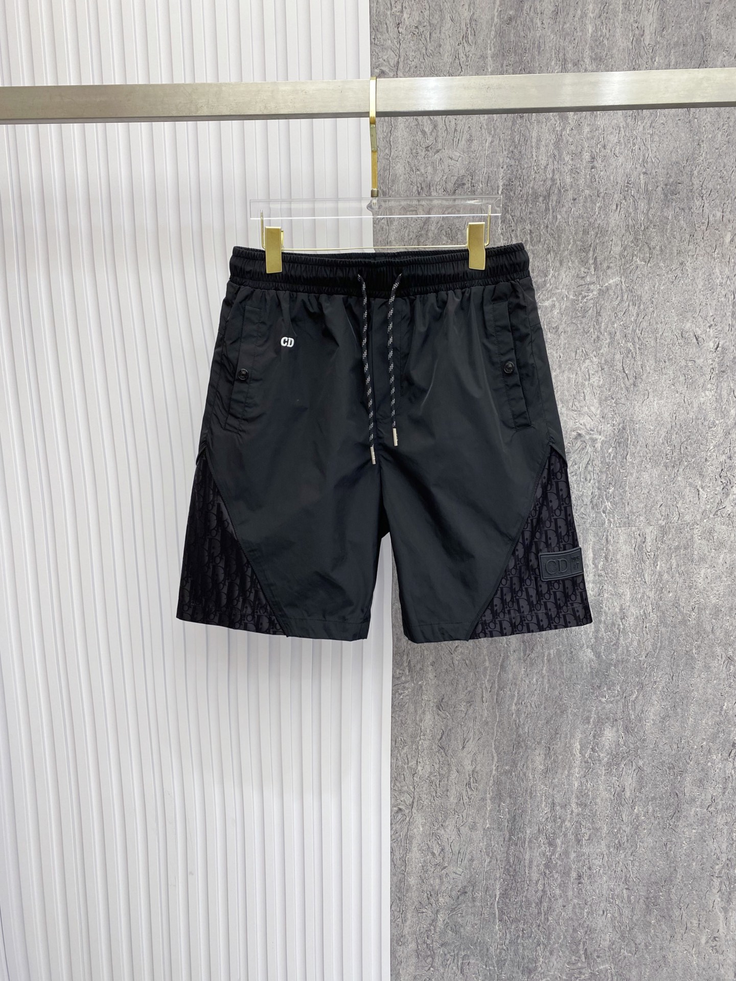 NO:842801,Dior Dior  2026ss summer Oblique presbyopic splicing series casual shorts, available in black/coffee colors, combine the brand's iconic elements with functional tailoring to create a new texture. Made of high-density anti-wrinkle nylon fabric, the upper body is light and breathable, with a smooth drape, without fear of summer heat and wrinkles; the waistband adopts a two-color drawstring elastic design  , with exquisite rope details, taking into account both comfort and sophistication. The Oblique presbyopia stitching on both sides of the pants, the HD logo on the front, and the three-dimensional DIOR patch pocket on the back are low-key to inject brand recognition. The neat straight silhouette modifies the leg shape. Whether it is daily life in the city or on vacation, you can easily wear a relaxed and noble summer style.  Color black coffee code number 48-56, dior, dior, shorts,19860909Dior 迪奥 2026ss夏季Oblique老花拼接系列休闲短裤,黑/咖双色可选,把品牌标志性元素与机能剪裁玩出了新质感.甄选高密抗皱锦纶面料打造,上身轻薄透气,自带顺滑垂坠感,无惧夏日闷热与褶皱；腰头采用双色抽绳松紧设计,搭配精致绳头细节,兼顾舒适与精致度.裤身两侧的Oblique老花拼接与正面HD标识、背面立体DIOR贴袋,低调注入品牌辨识度,利落直筒版型修饰腿型,无论是都市日常还是度假出行,都能轻松穿出松弛显贵的夏日格调. 颜色黑色 咖色 码数48-56,,dior,dior,shorts,,Men's clothing